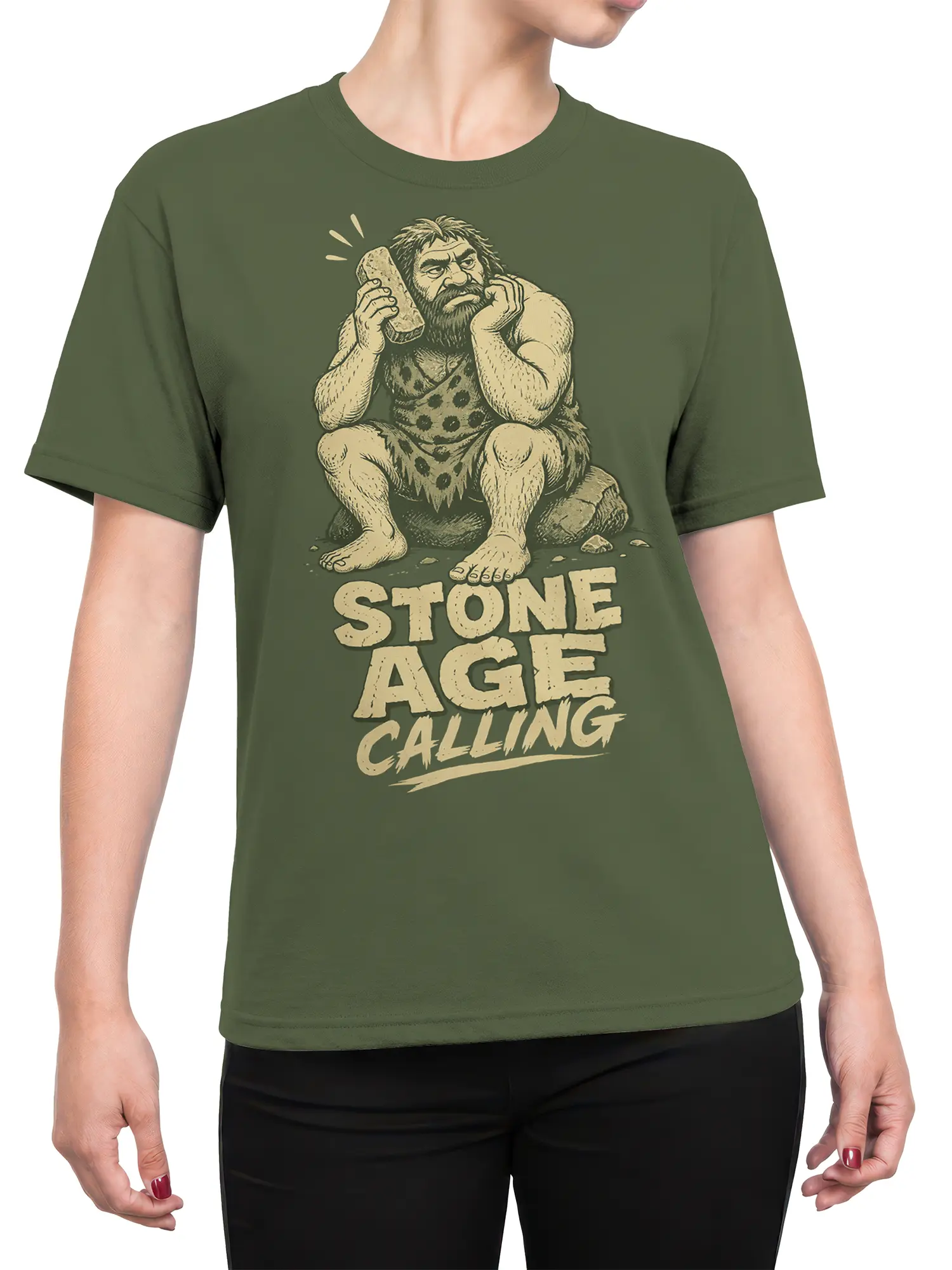Female torso wearing a green caveman T-shirt with stone phone artwork and vintage “STONE AGE CALLING” text
