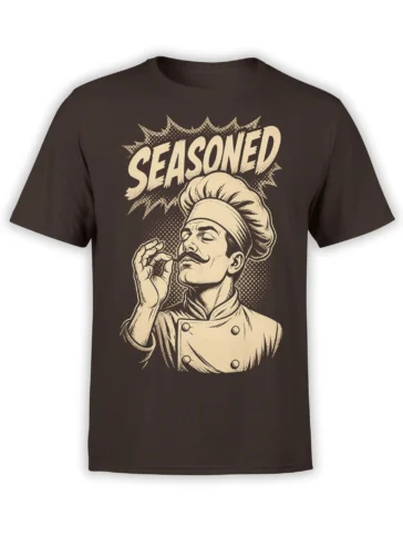 Brown T-shirt with a vintage mustached chef illustration, tall hat, cream “SEASONED” lettering, and comic-style halftone shading