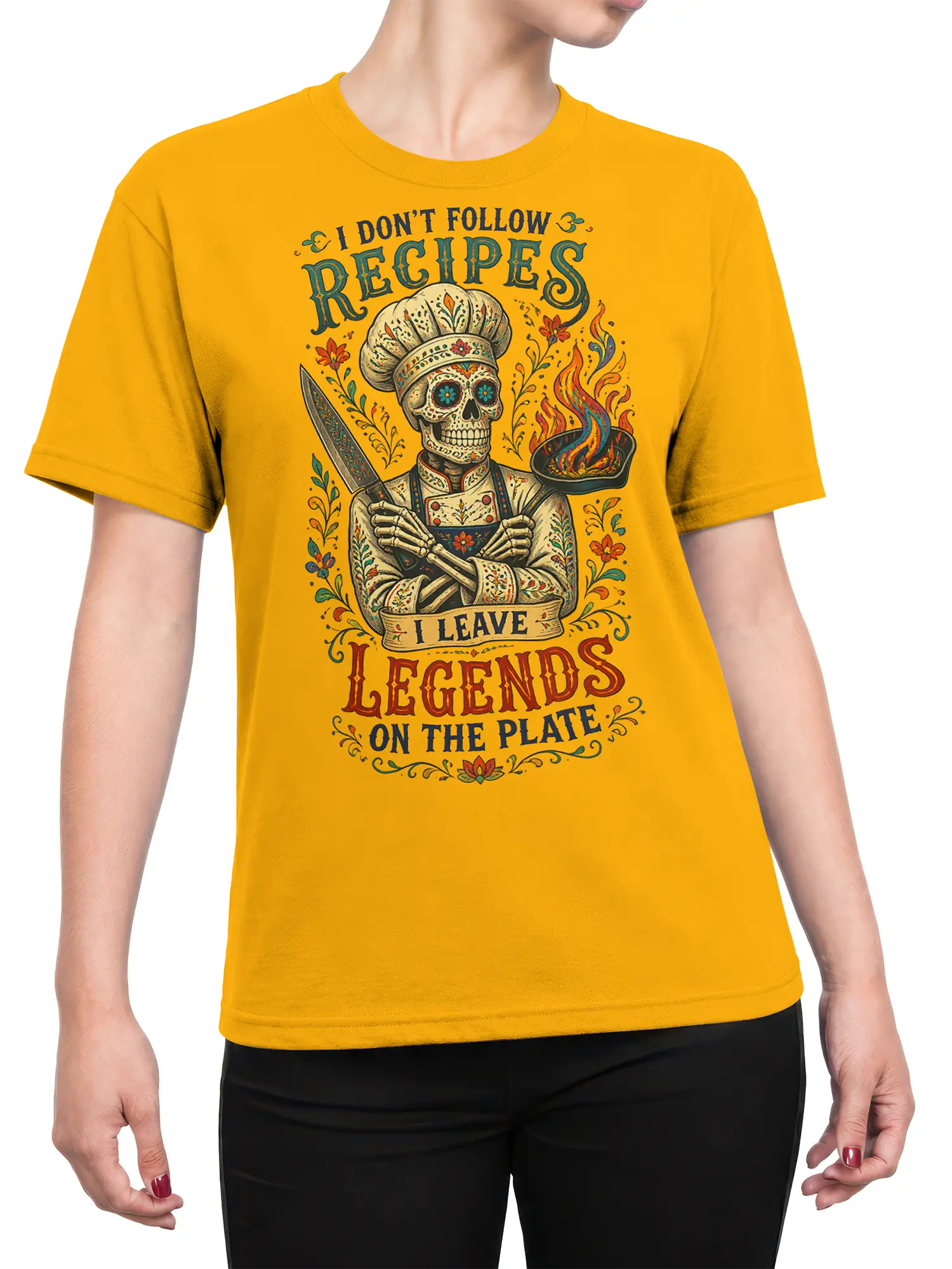 Female torso wearing a yellow T-shirt with skeleton chef, knife, flaming pan, and vintage food artwork
