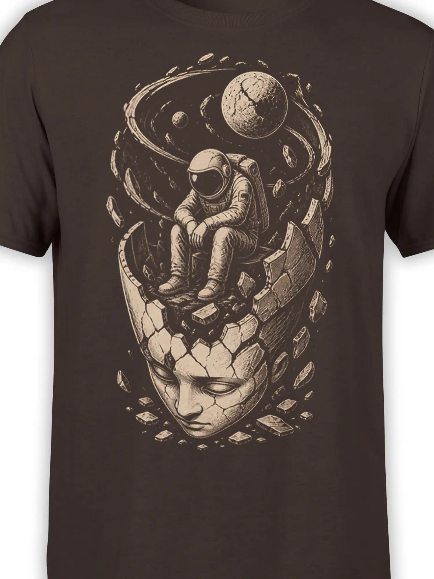 Close-up of the seated astronaut, cracked face, planets, and cosmic debris on a brown graphic T-shirt