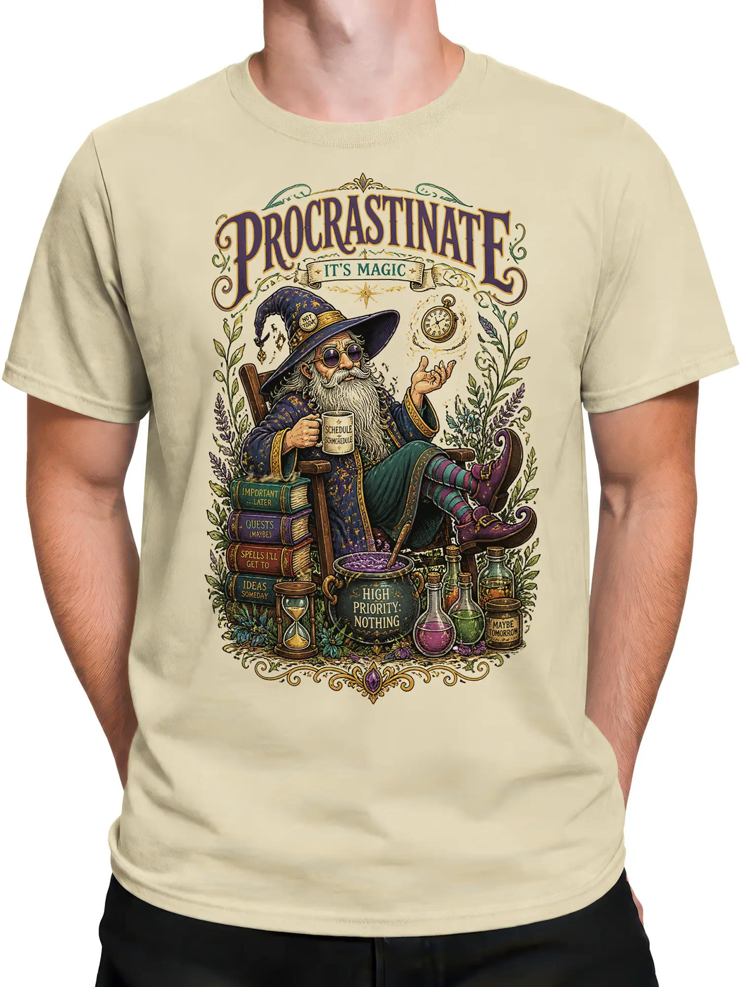 Male torso wearing a beige fantasy T-shirt with a vintage wizard, magic books, and procrastination-themed artwork