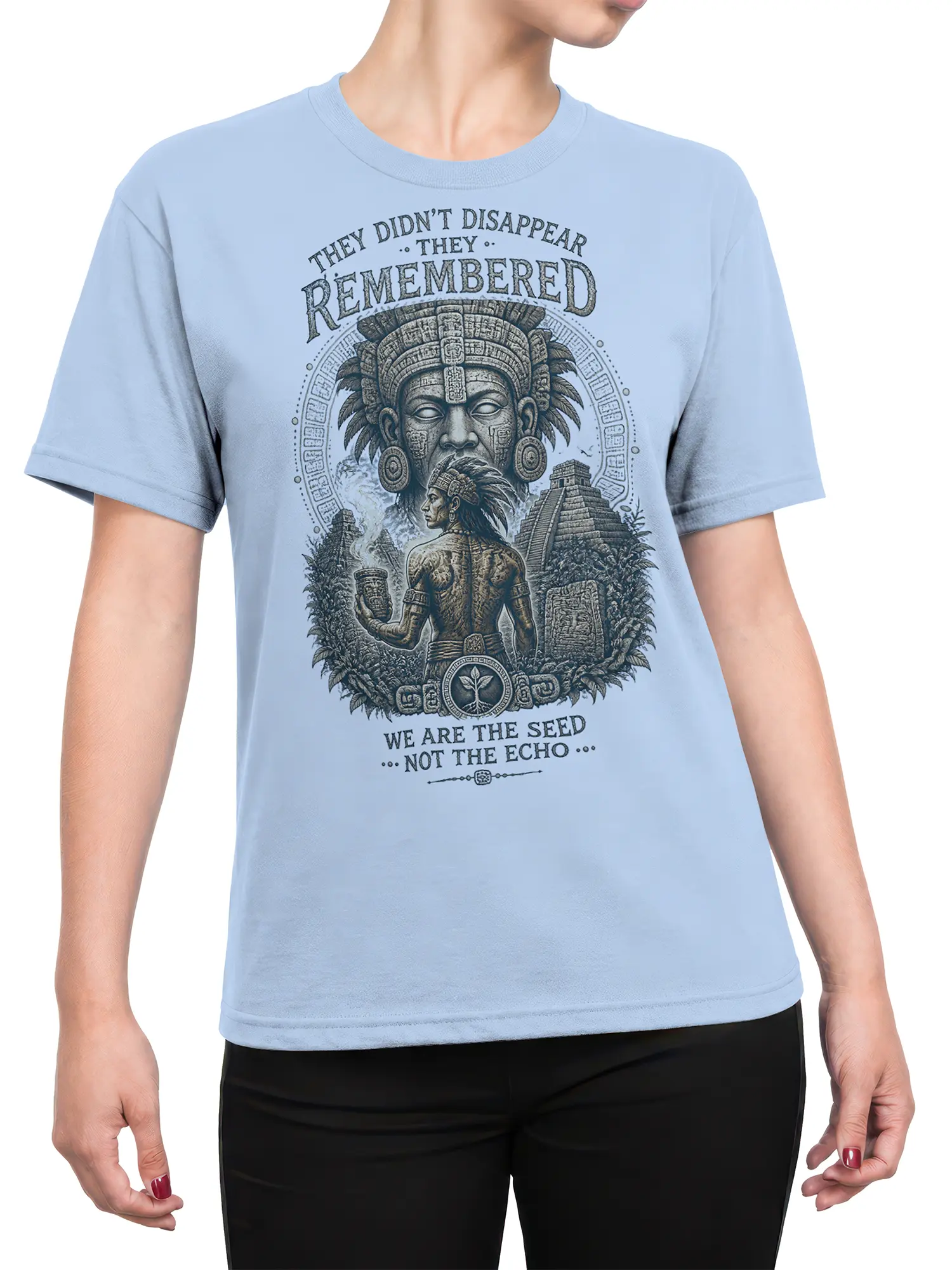 Female torso wearing a light blue T-shirt with indigenous warrior and ancient temple artwork