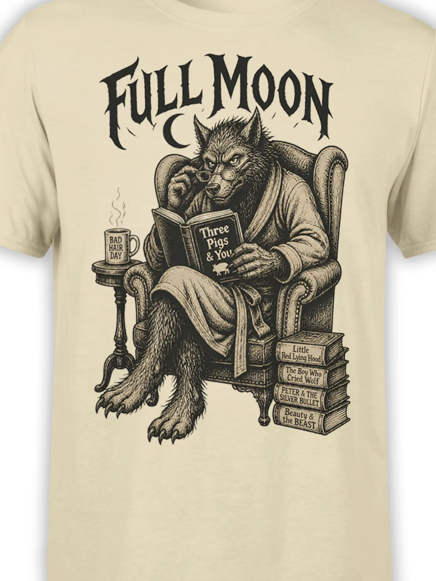 Close-up of the beige shirt design showing a reading wolf, full moon text, books, and vintage storybook details