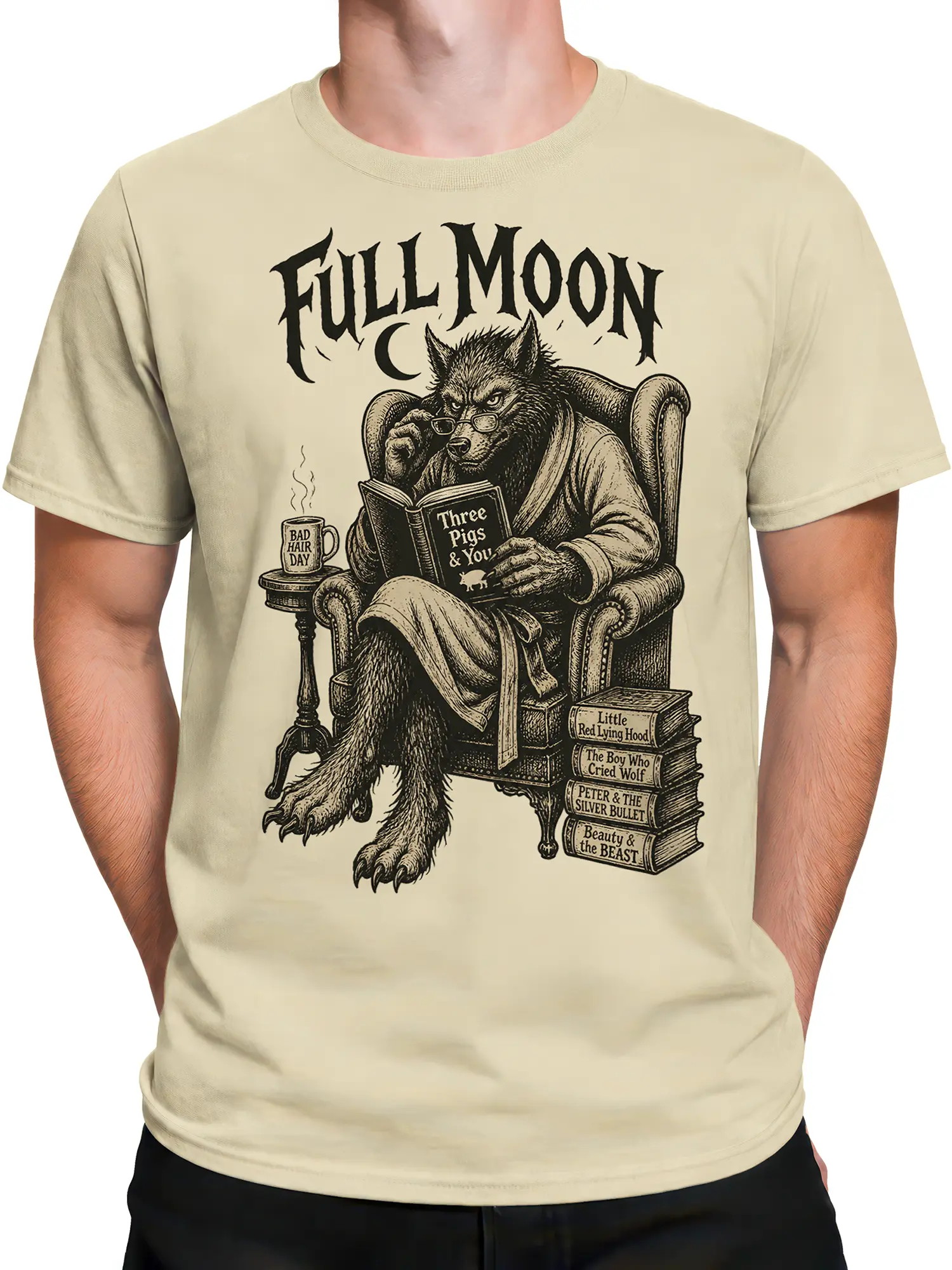 Male torso wearing a beige wolf reading T-shirt with glasses, books, and full moon artwork
