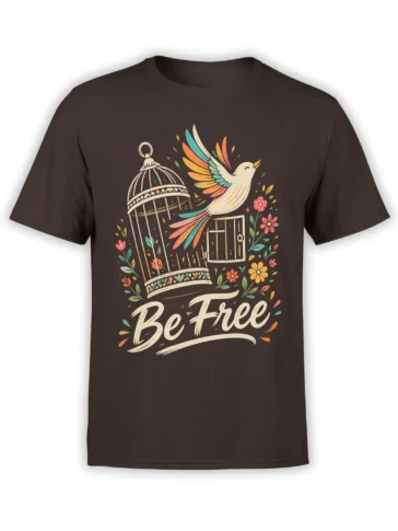 Colorful white bird escaping a decorative cage with flowers and “Be Free” lettering on a dark brown T-shirt