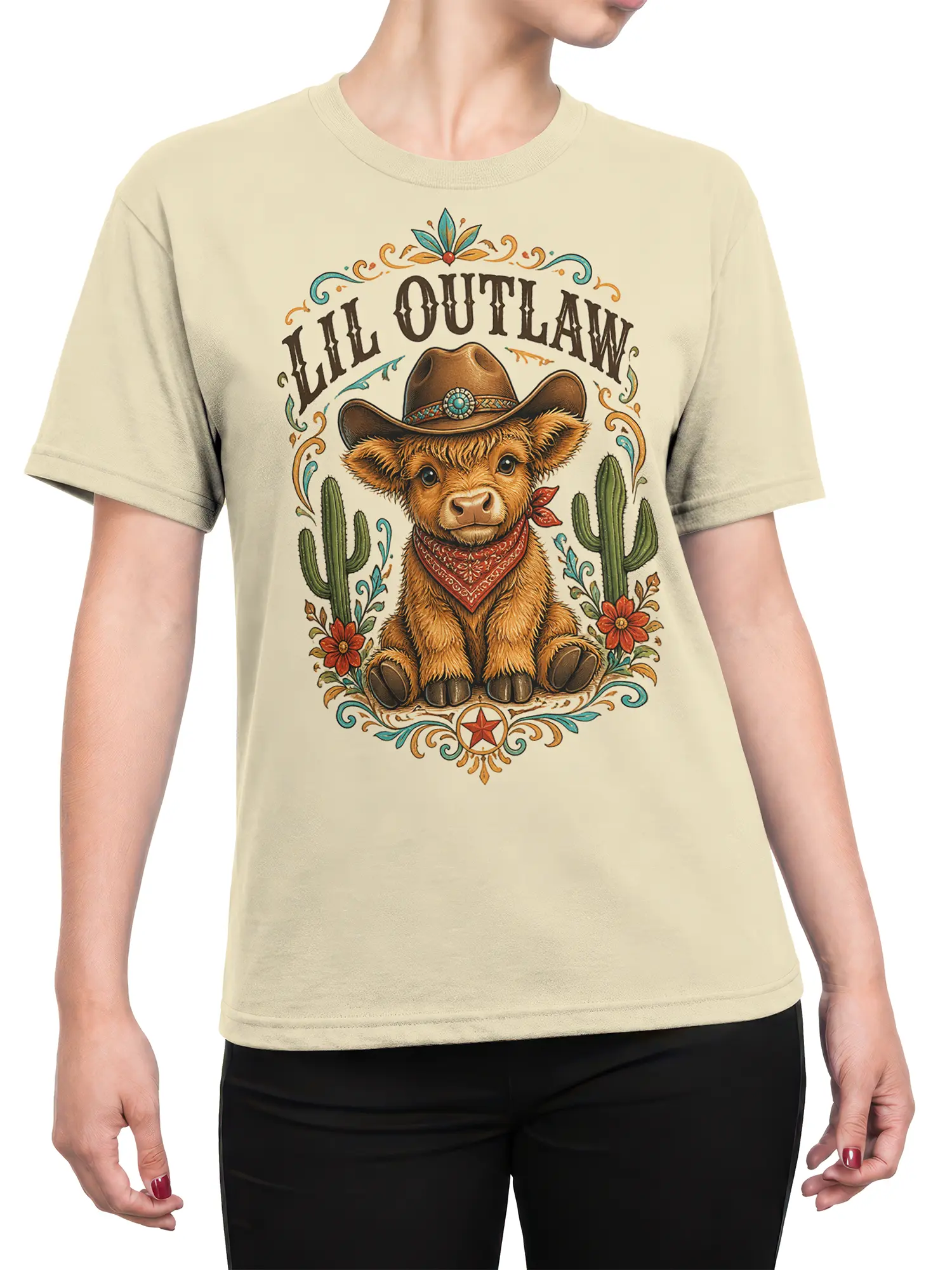 Female torso wearing a beige T-shirt with a highland cow cowboy graphic and western ALL OUTLAW design