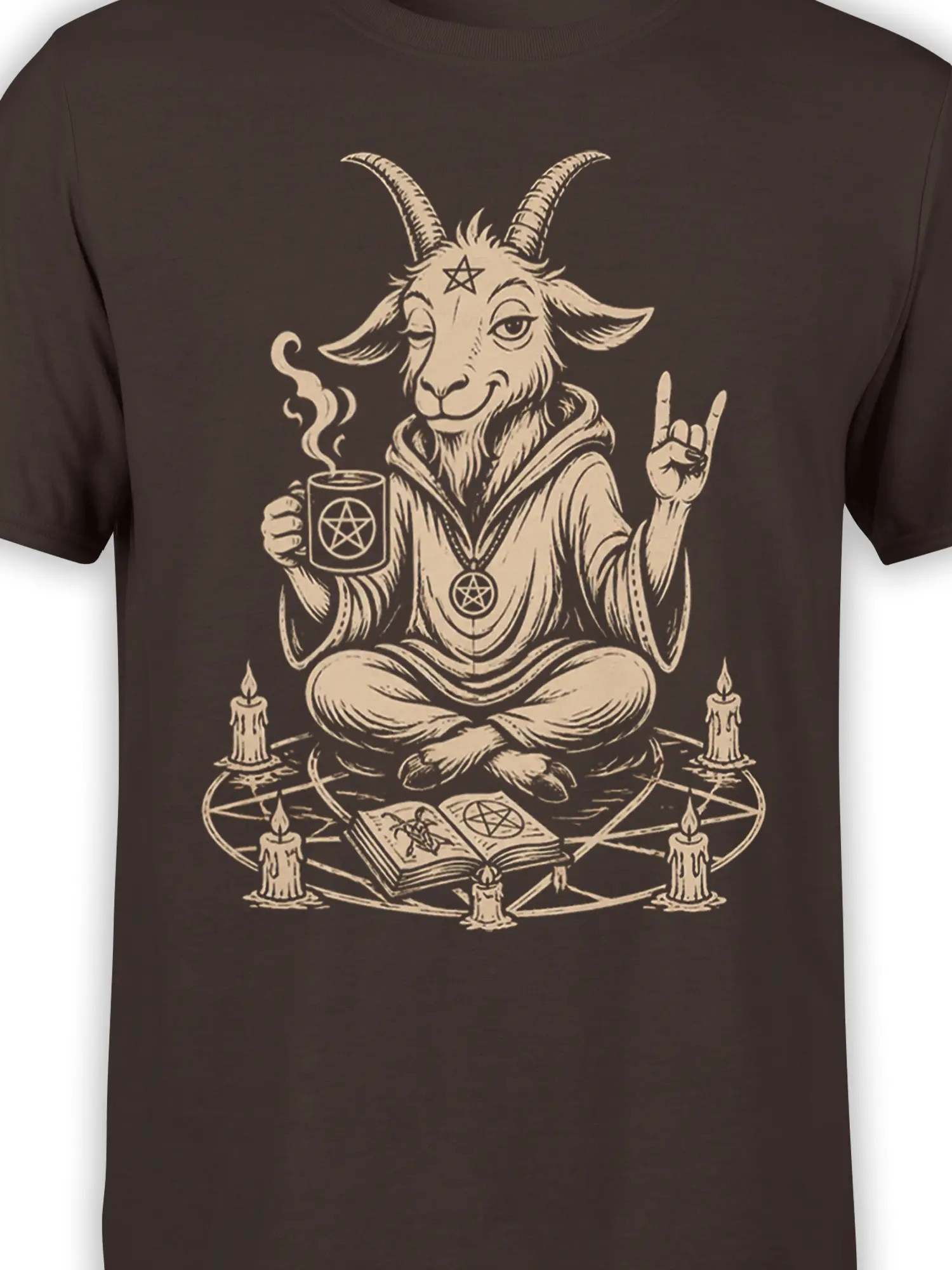 Close-up of horned goat artwork with pentagrams, robe details, steaming mug, and cream line art on a brown T-shirt