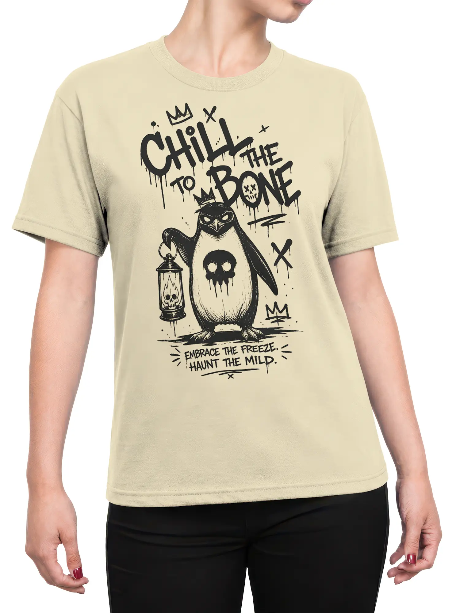 Female torso wearing a beige T-shirt with crowned penguin, skull lantern, and dark Chill to the Bone artwork