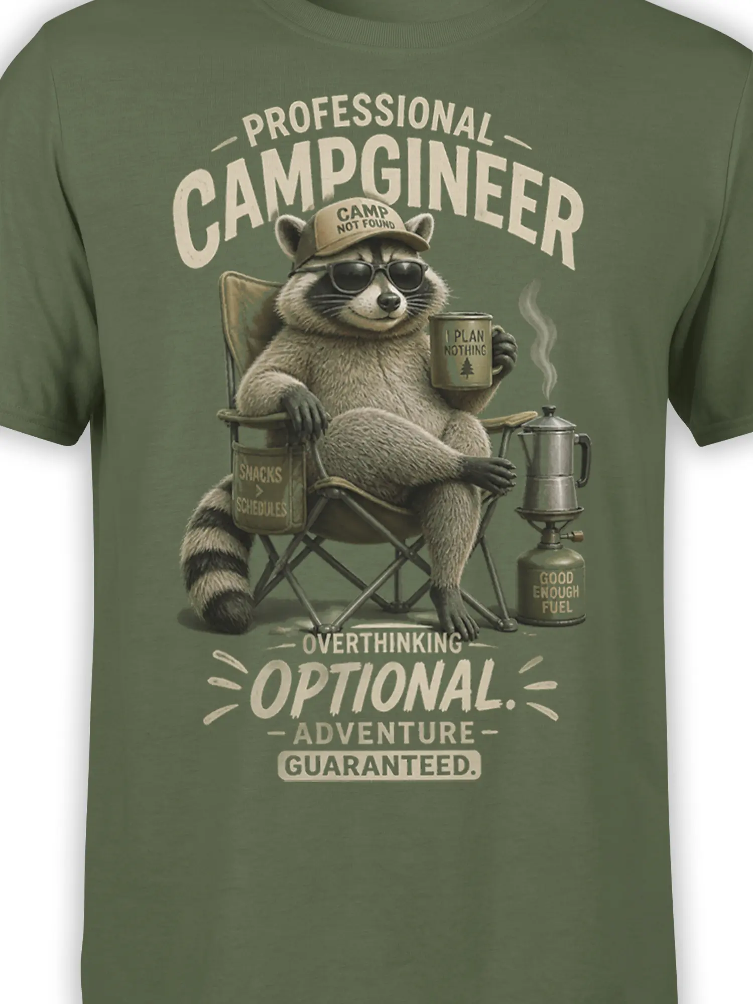 Close-up of raccoon camper artwork and cream lettering on a green camping T-shirt