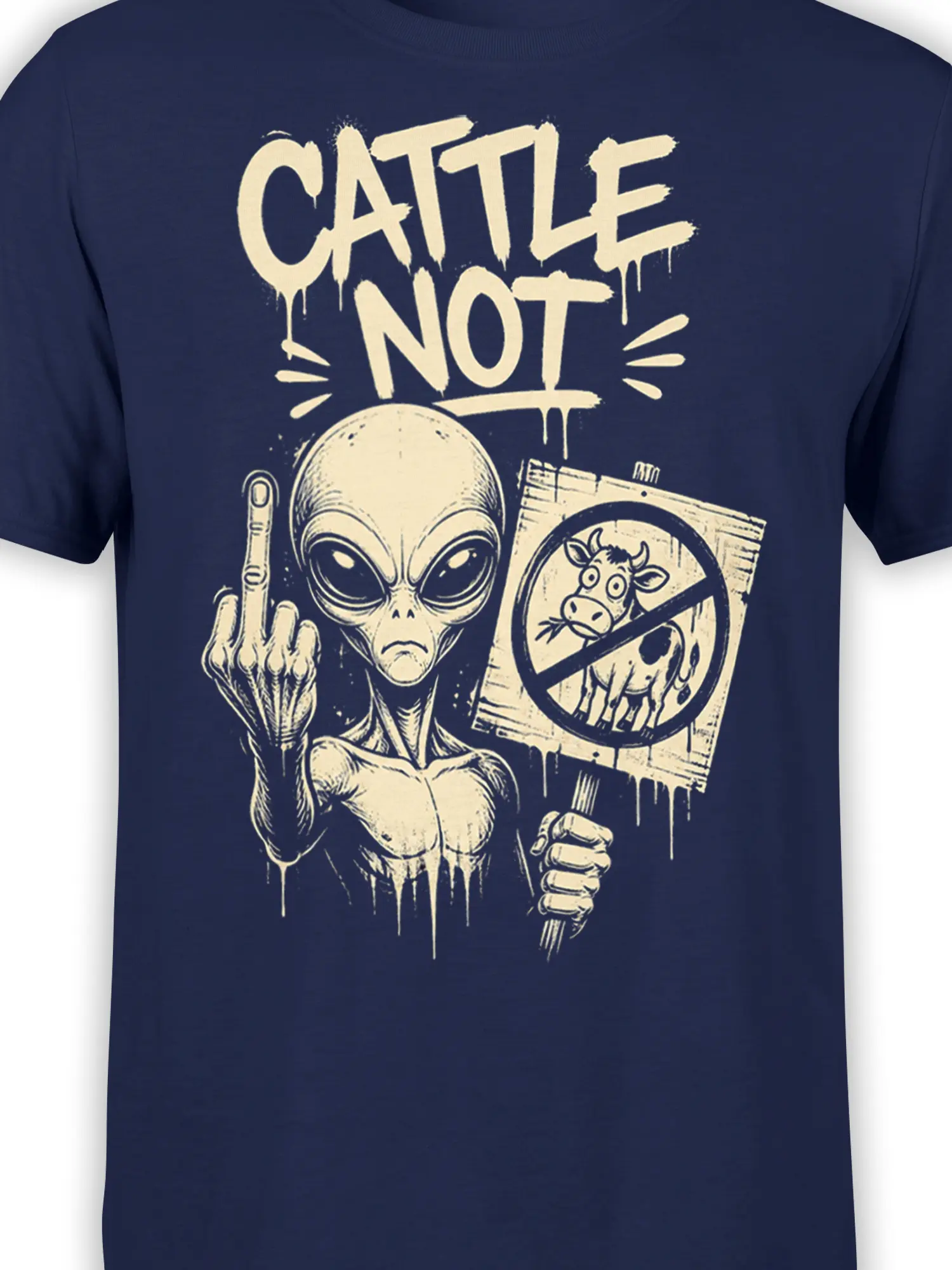 Close-up of cream alien artwork with “CATTLE NOT” lettering and crossed-out cow sign on navy fabric