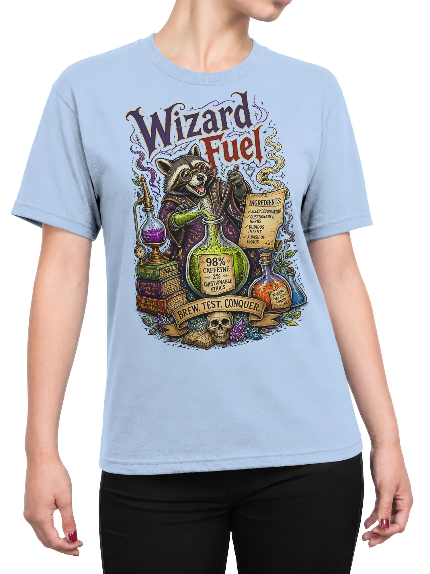 Female torso wearing a light blue T-shirt with a caffeinated raccoon wizard and potion artwork