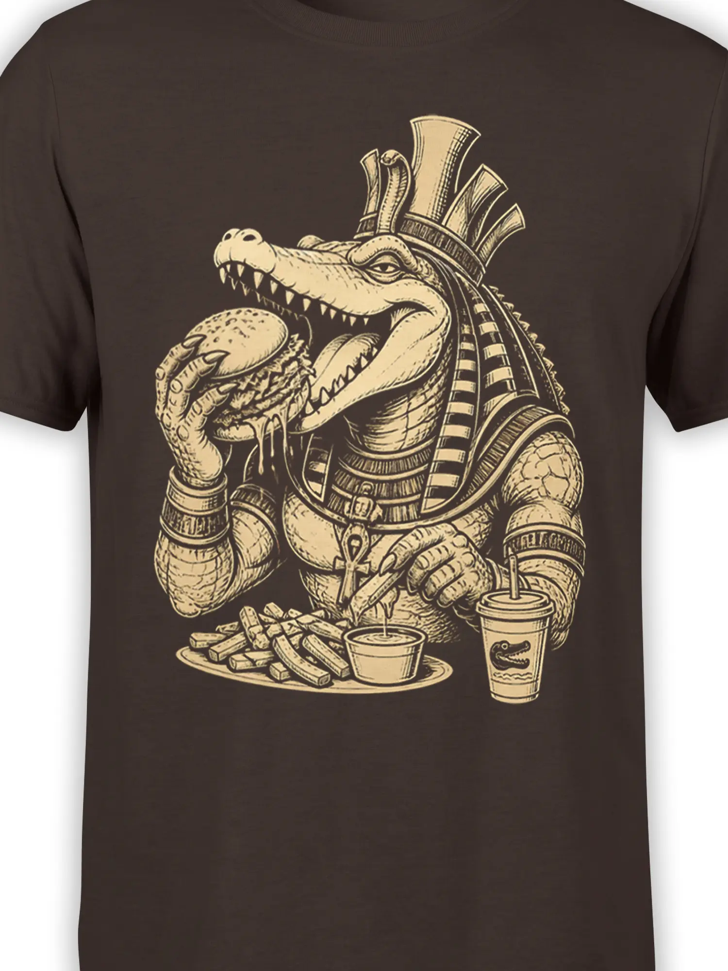 Close-up of crocodile pharaoh artwork with burger, fries, ankh, and drinks on a brown shirt