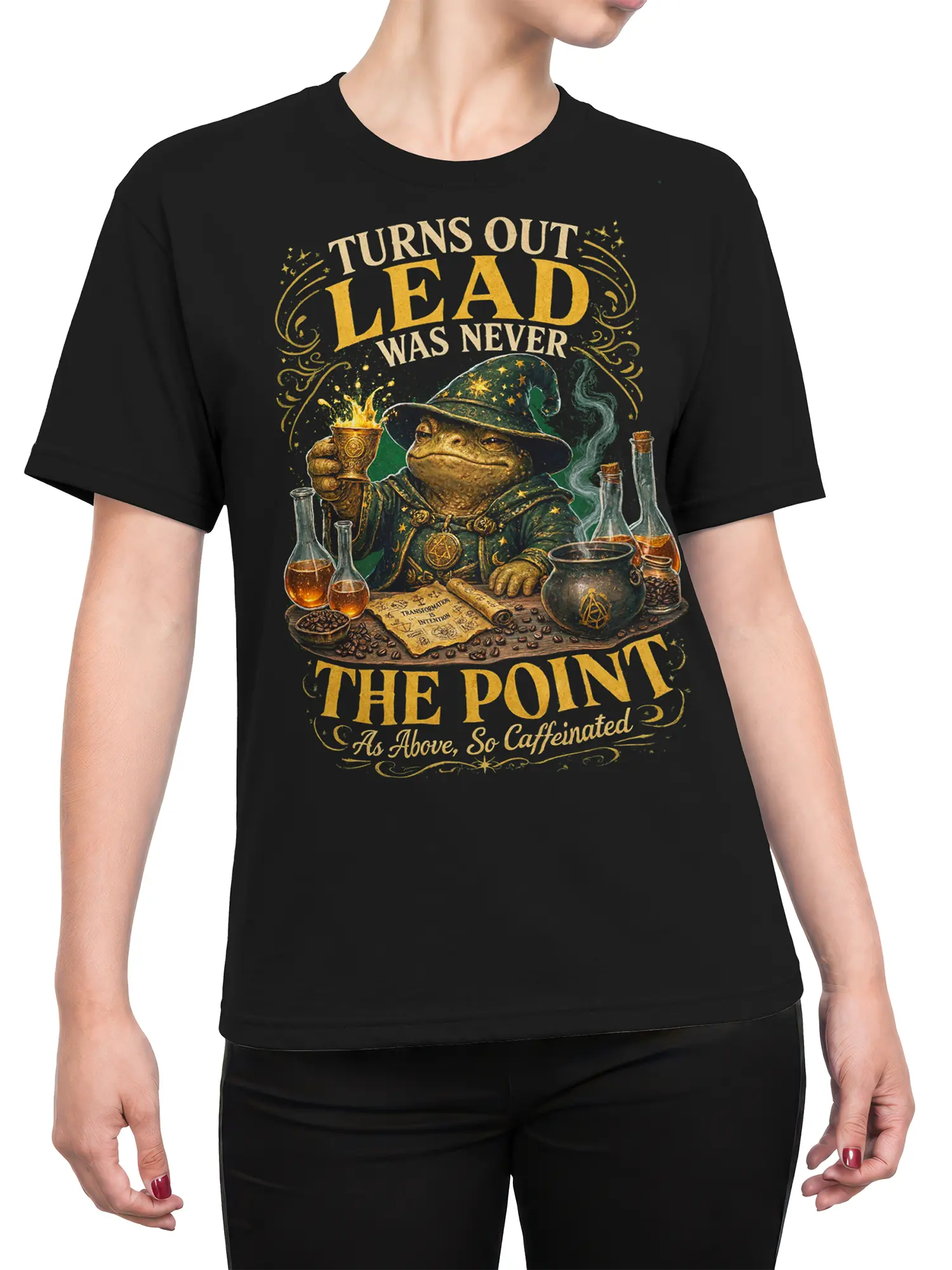 Female torso wearing a black shirt with a wizard frog alchemist coffee graphic and vintage gold lettering