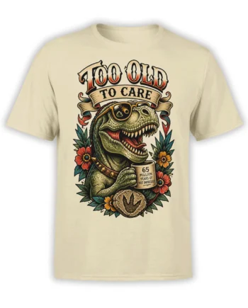 Beige T-shirt with a vintage green T. rex, eyepatch, coffee mug, flowers, and “Too Old to Care” artwork