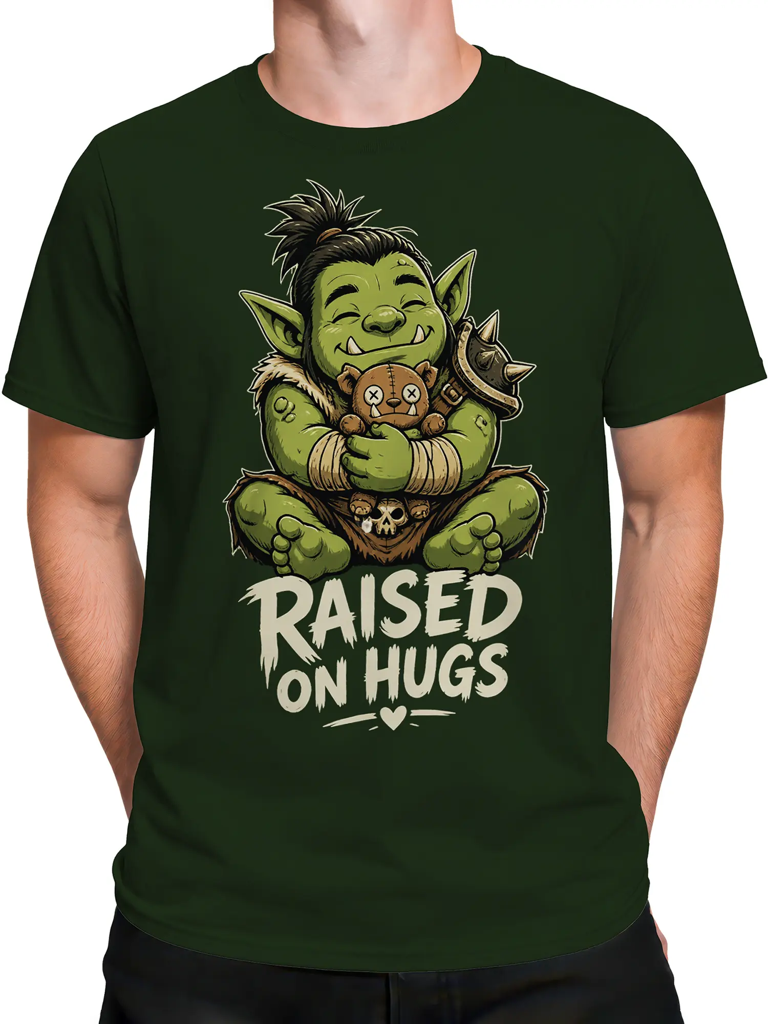Male torso wearing a dark green fantasy graphic shirt with a goblin, teddy bear, and “RAISED ON HUGS” lettering