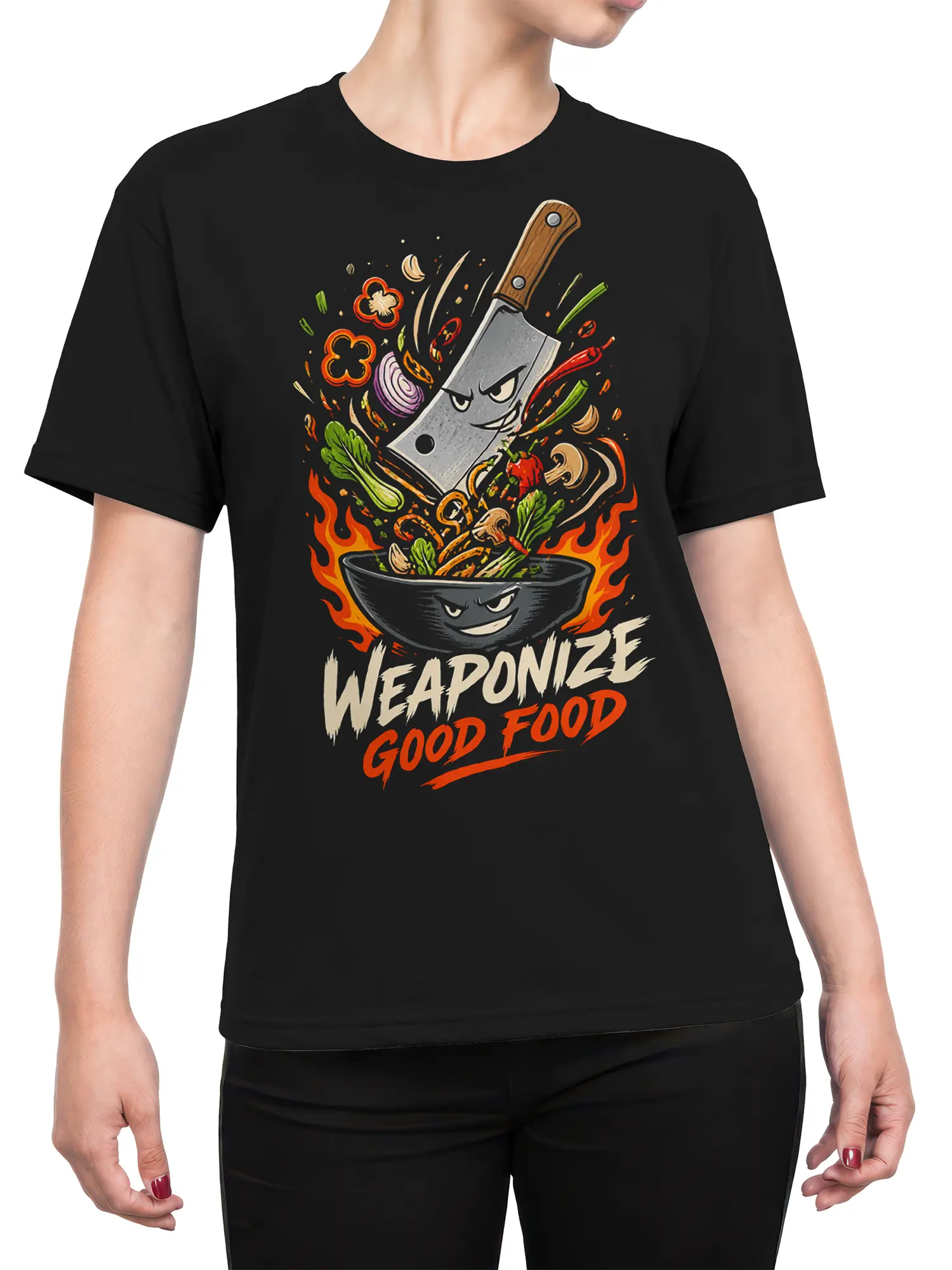 Female torso wearing a black T-shirt with a fiery cleaver, grinning bowl, vegetables, flames, and kitchen slogan graphic