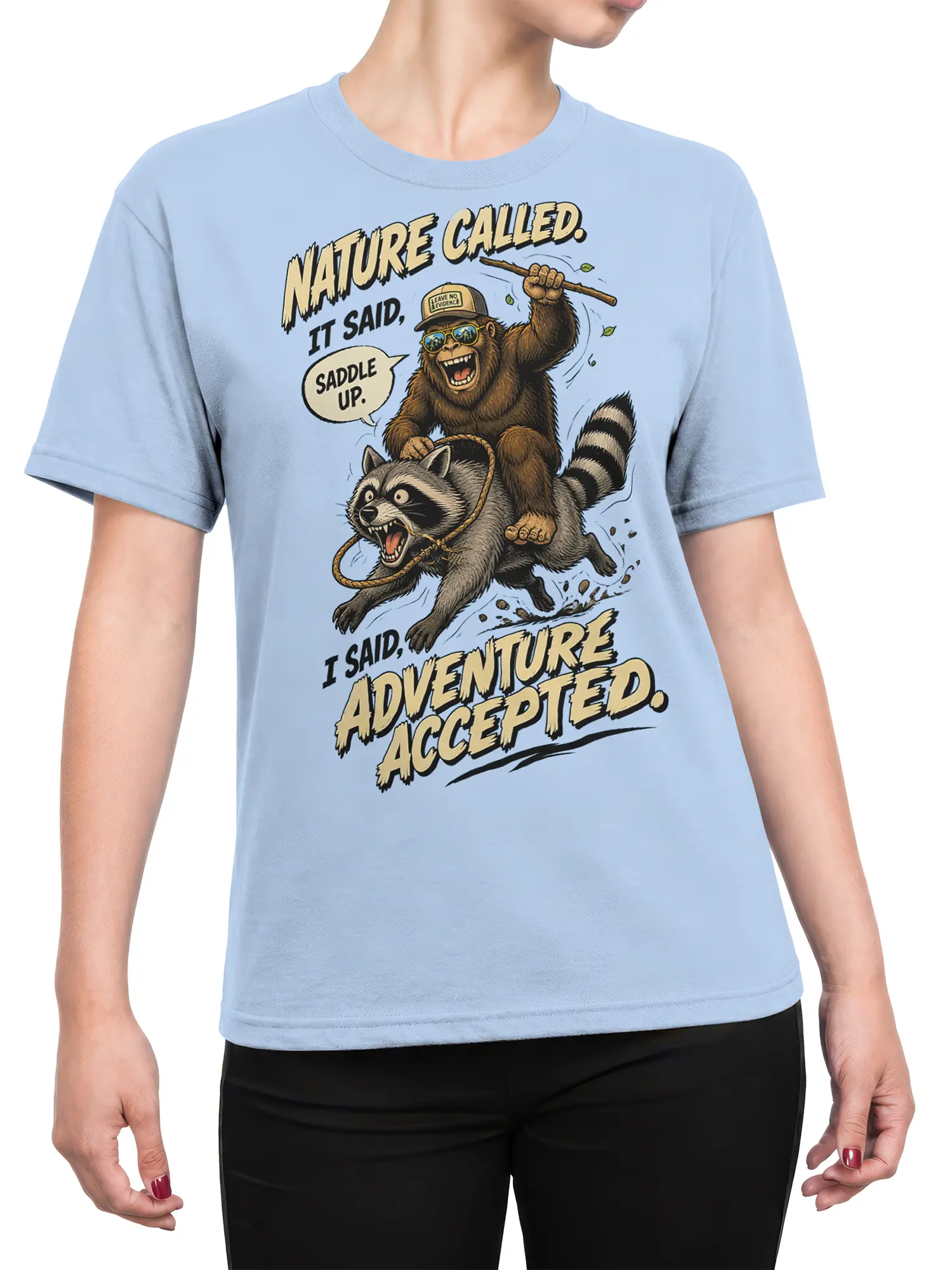 Female torso wearing a light blue raccoon adventure T-shirt with a monkey rider graphic