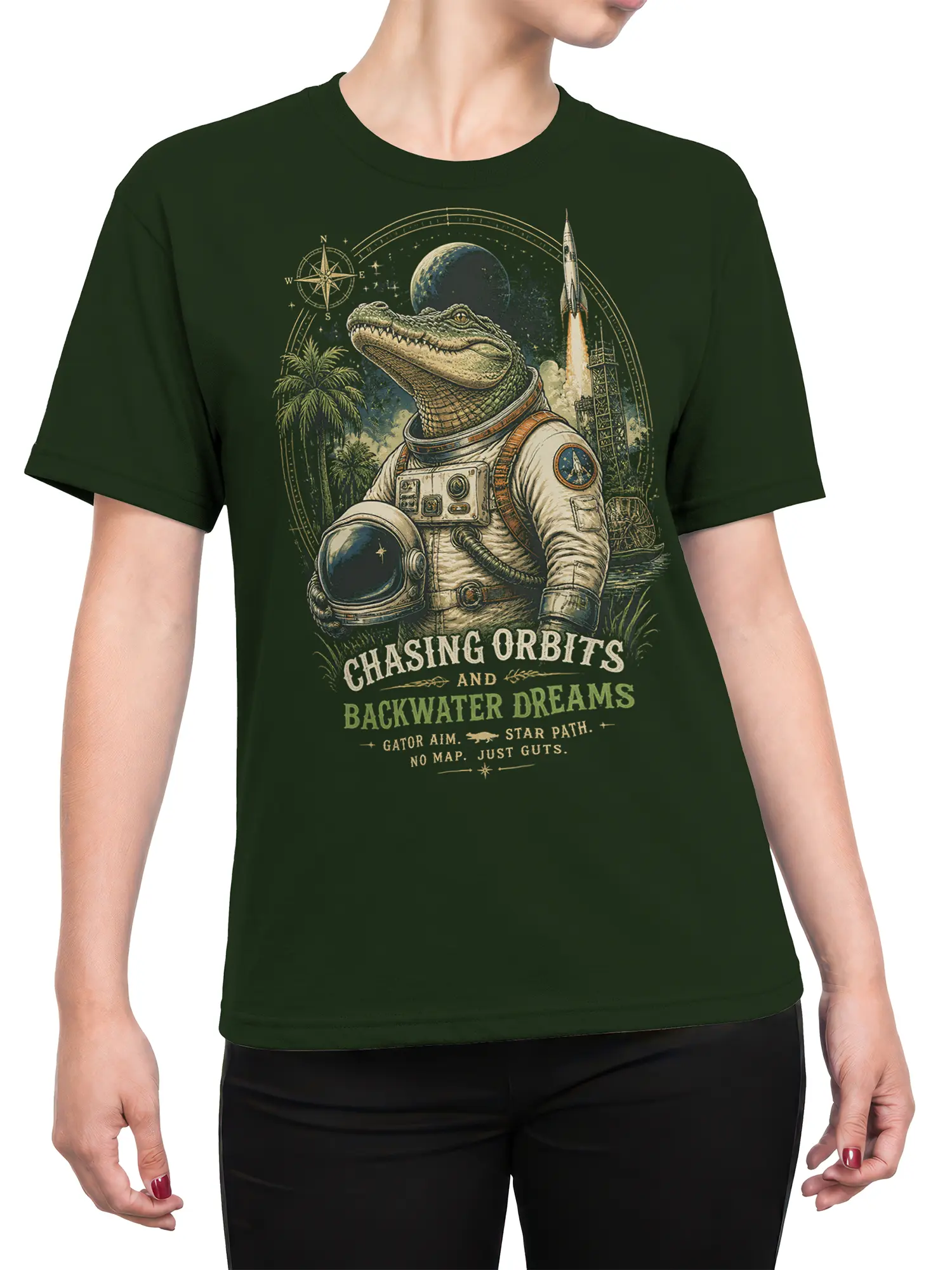 Female torso wearing a green T-shirt with an alligator astronaut, rocket, planet, and vintage space adventure graphic