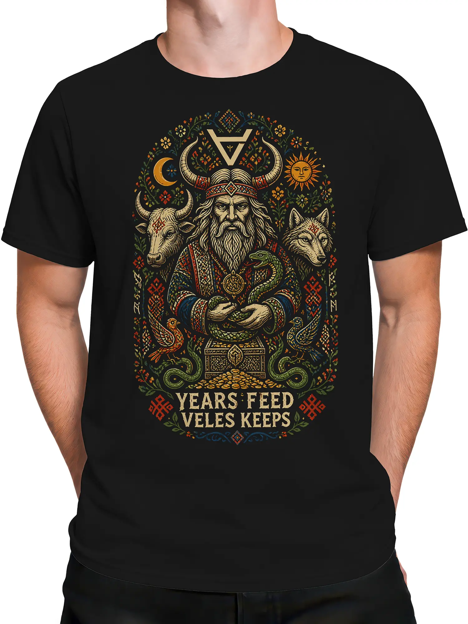 Male torso wearing a black mythology T-shirt with a horned figure, wolf, bull, snakes, and ornamental symbols