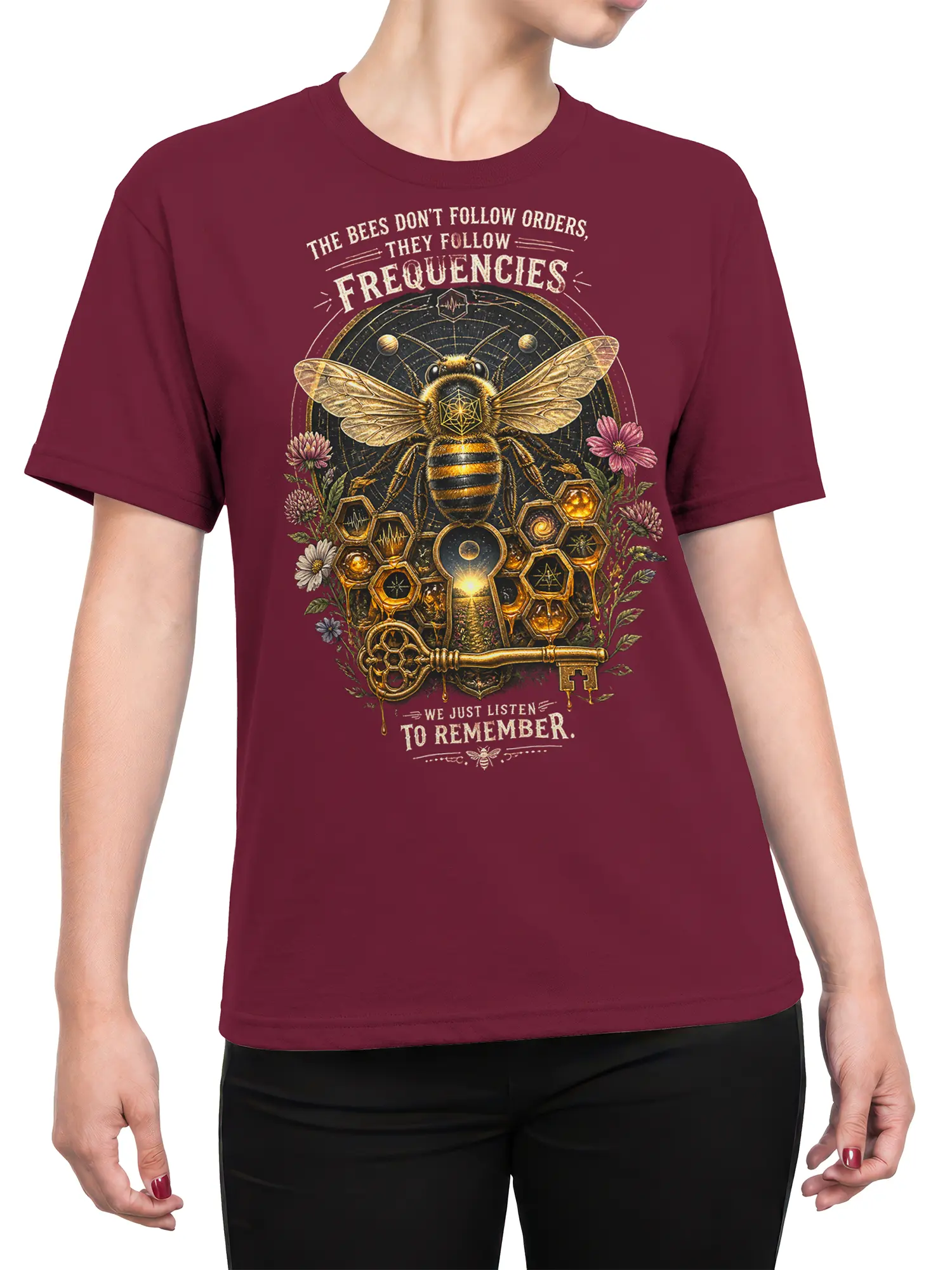 Female torso wearing a burgundy bee graphic tee with sacred geometry, flowers, and a golden key
