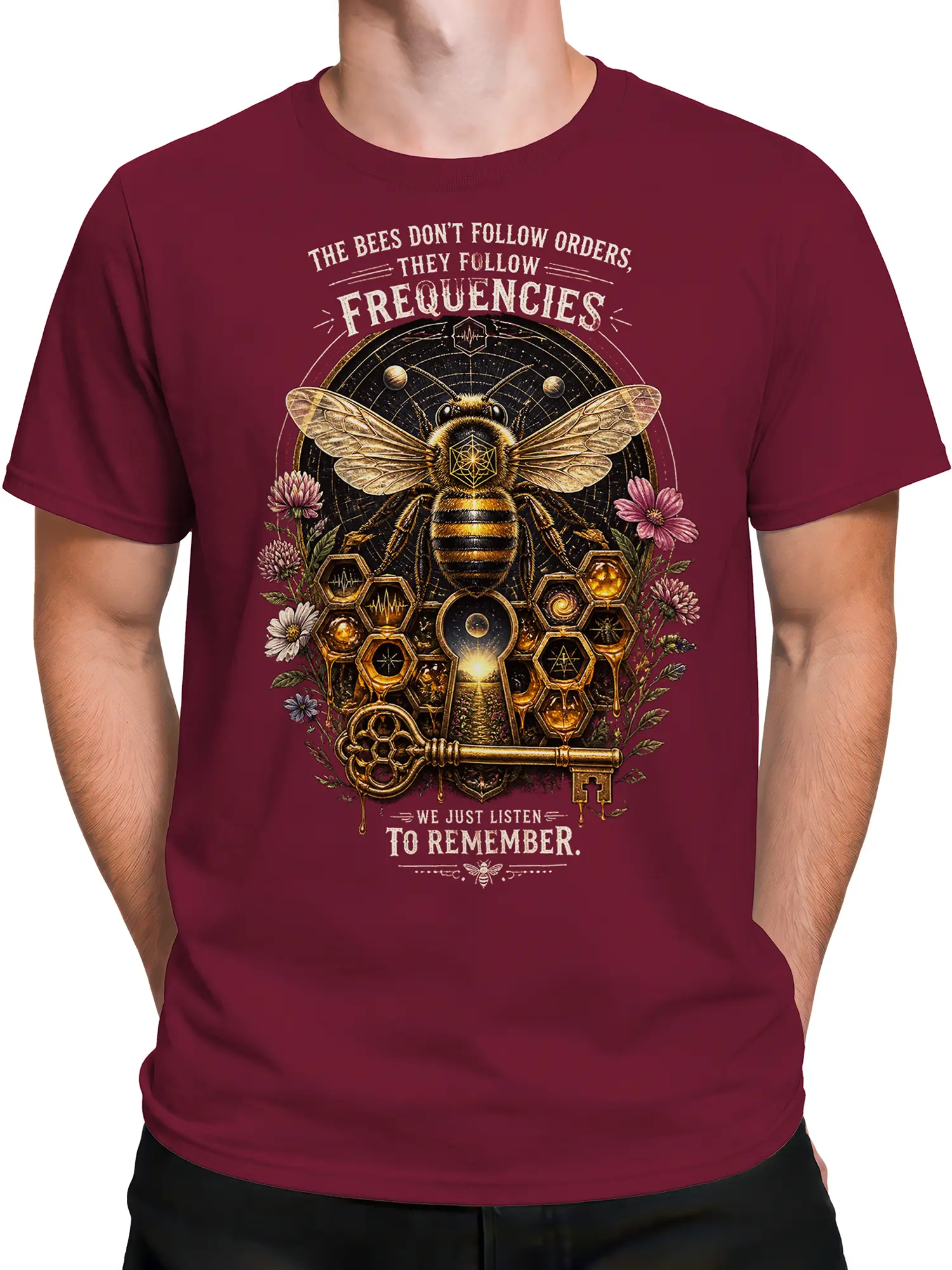 Male torso wearing a burgundy mystical bee tee with flowers, hexagons, and a vintage frequency message