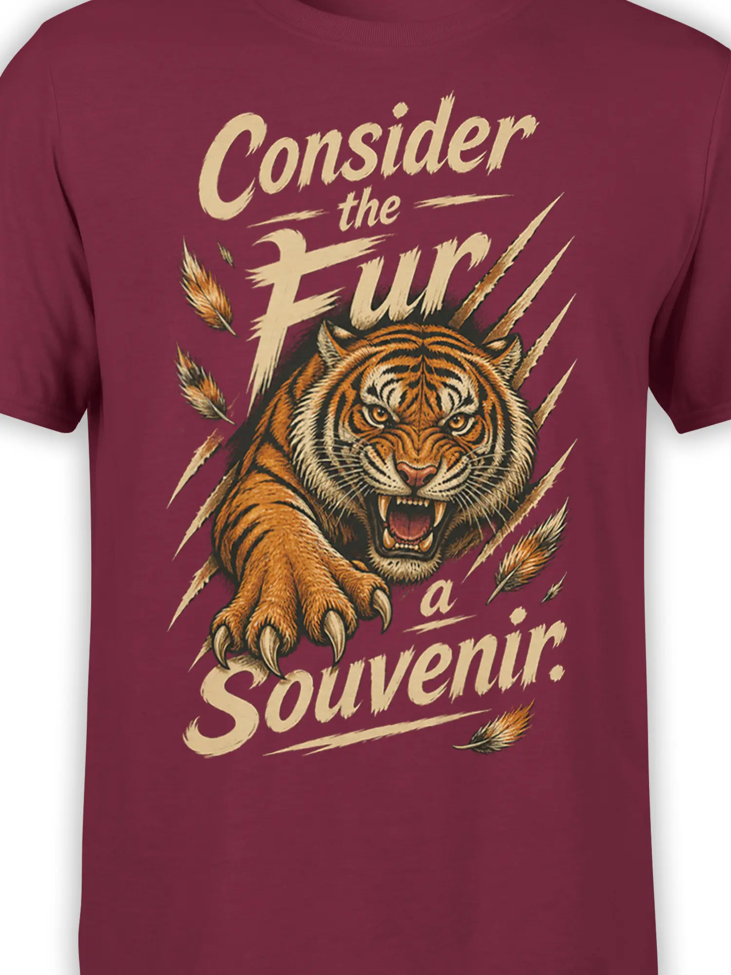 Close-up of roaring tiger artwork and distressed cream lettering printed on a burgundy graphic T-shirt