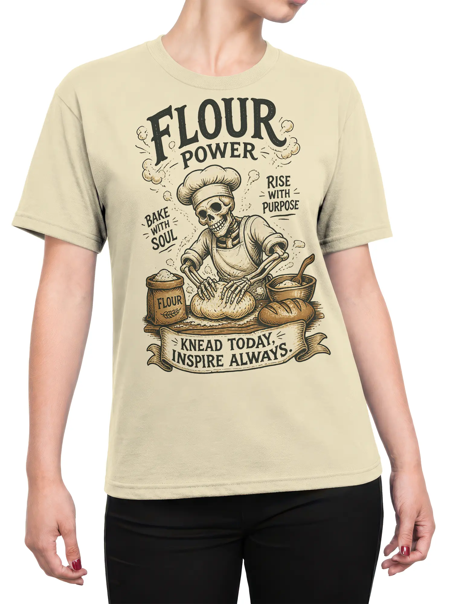 Female torso wearing a beige skeleton baker T-shirt with Flour Power graphic and vintage baking artwork