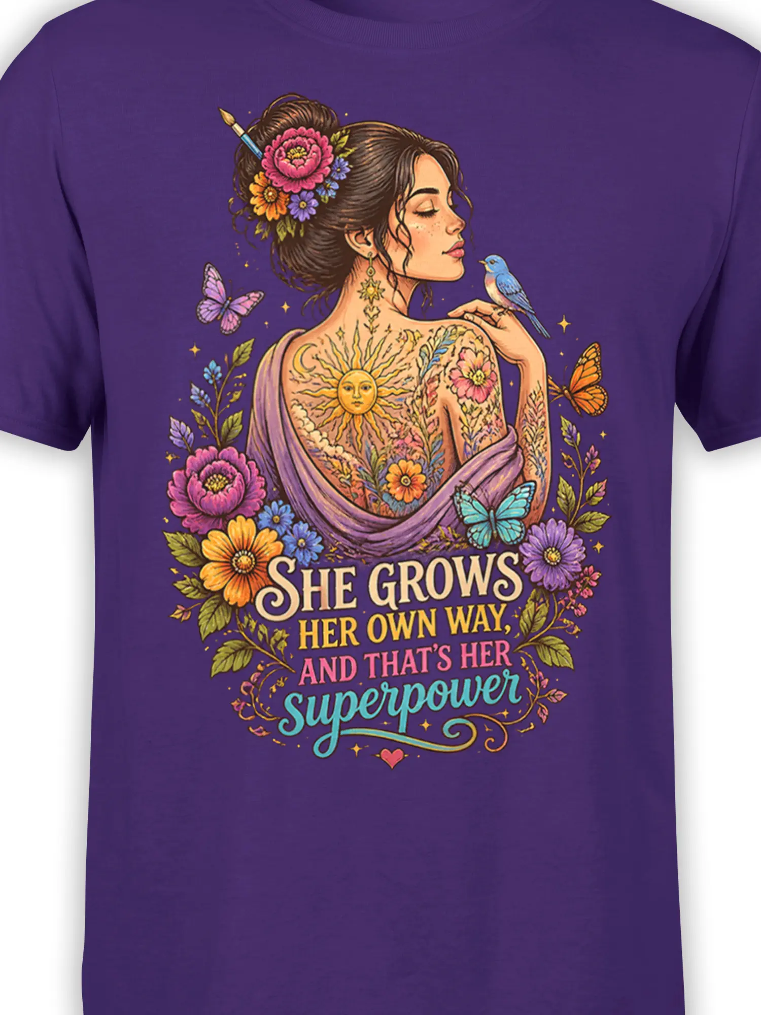 Close-up of floral woman artwork with butterflies, blue bird, sun, and empowerment lettering on purple fabric