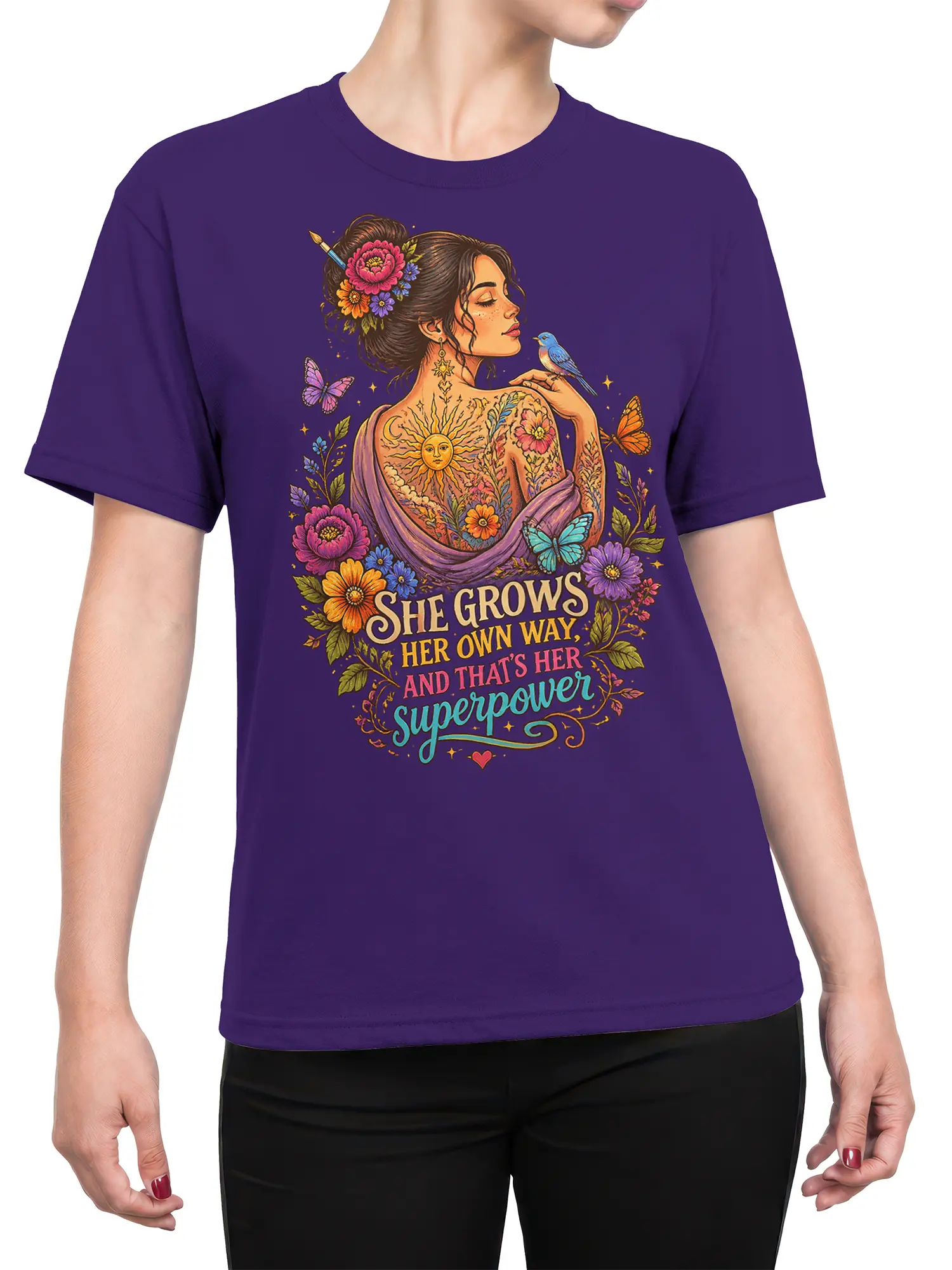 Female torso wearing a purple T-shirt with colorful floral woman artwork and self-growth empowerment lettering