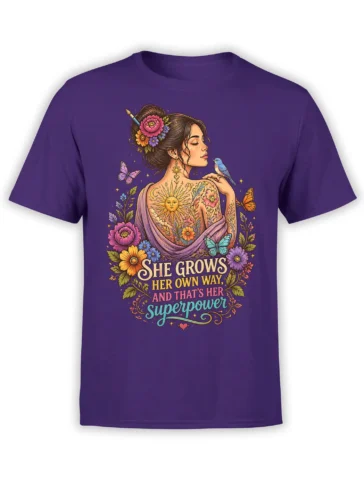 Purple T-shirt with a floral woman portrait, butterflies, blue bird, sun, and “She Grows Her Own Way” lettering