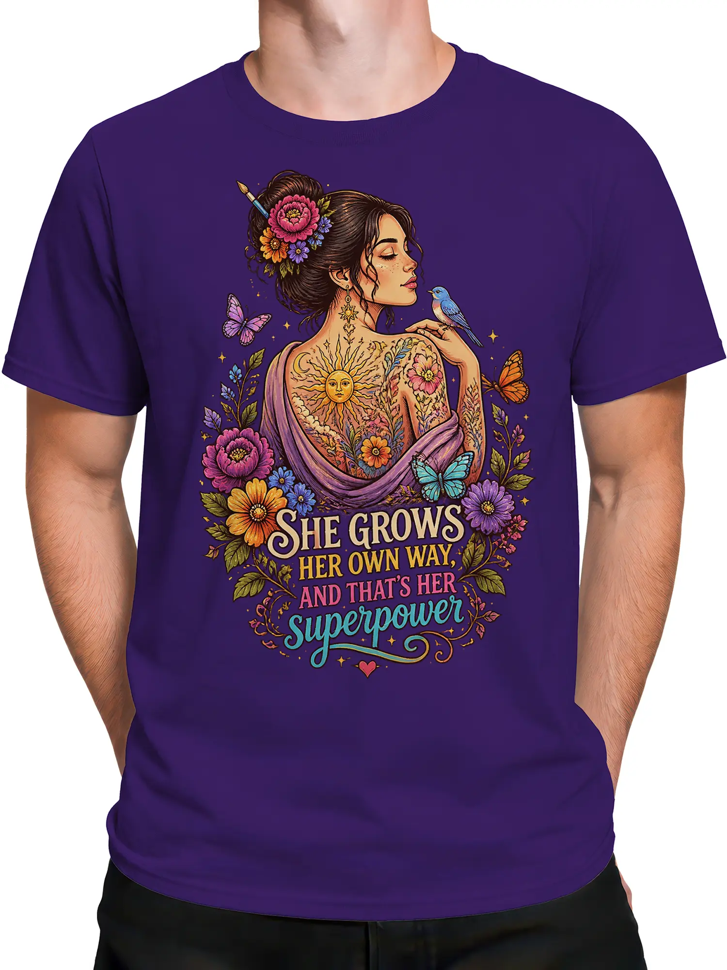 Male torso wearing a purple empowerment T-shirt with floral woman, butterfly, bird, and sun artwork