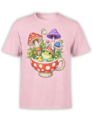 Pink T-shirt with a whimsical green frog in a mushroom teacup, surrounded by colorful mushrooms and clovers