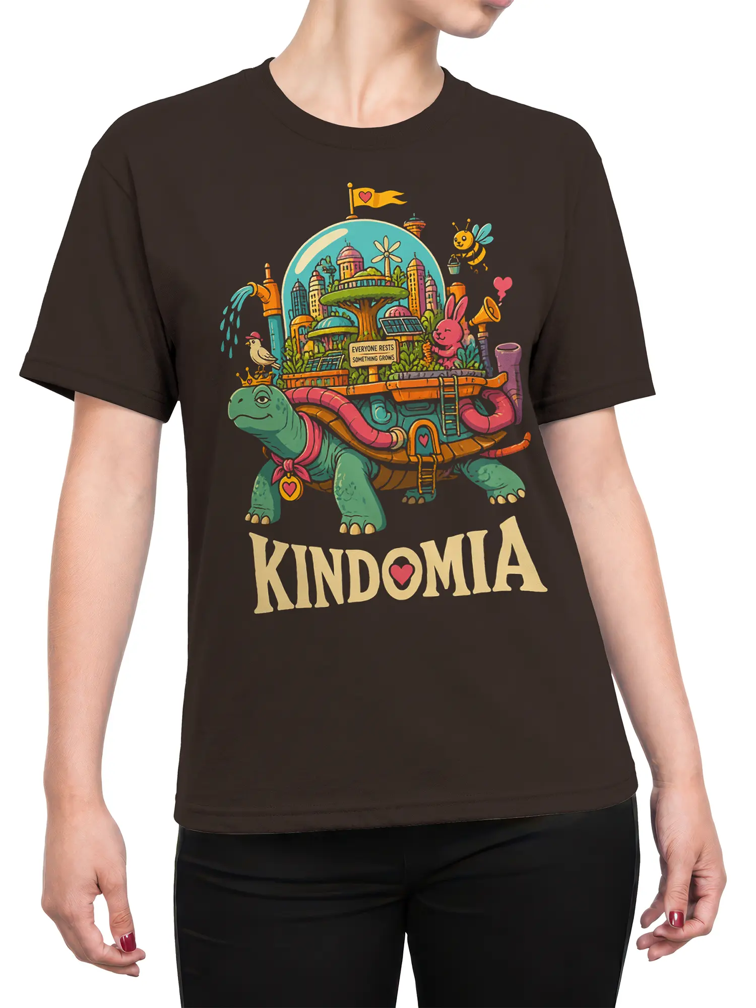 Female torso wearing a brown turtle graphic tee with a colorful city, animals, and KINDOMIA design
