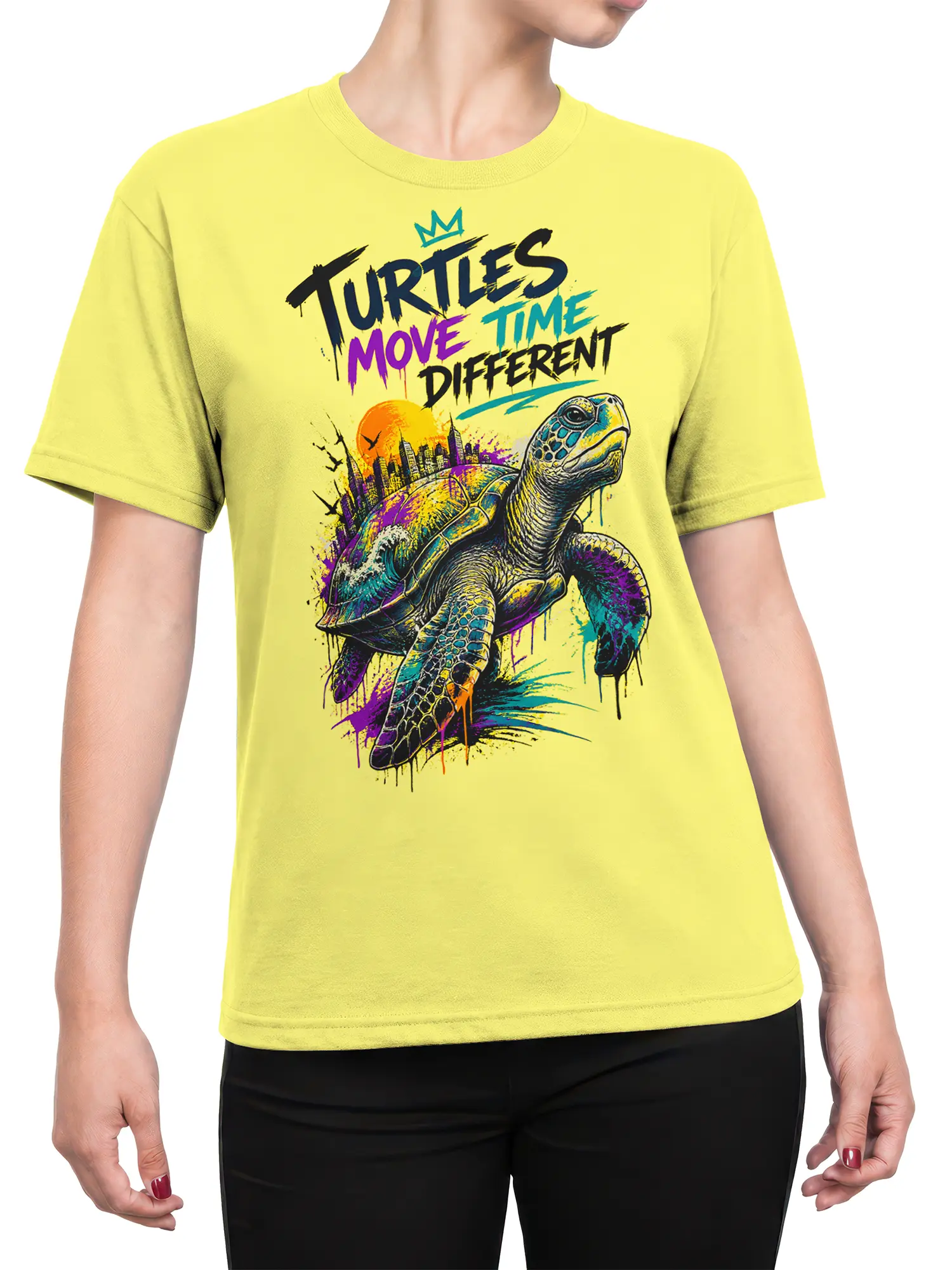 Female torso wearing a yellow turtle graphic tee with colorful urban artwork and bold brush-style lettering