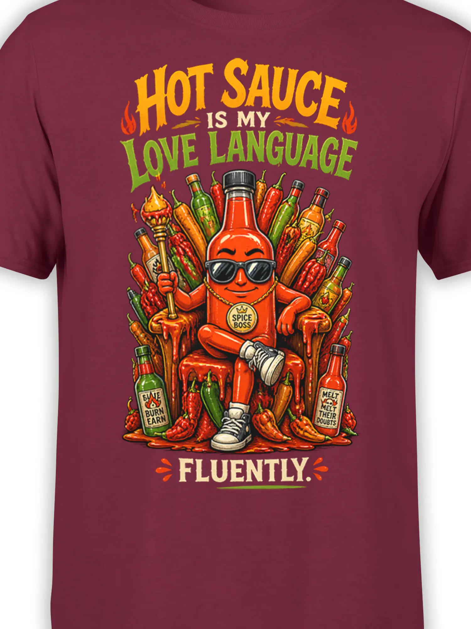 Close-up of the Spice Boss hot sauce bottle, peppers, sauce bottles, and lettering on a burgundy T-shirt