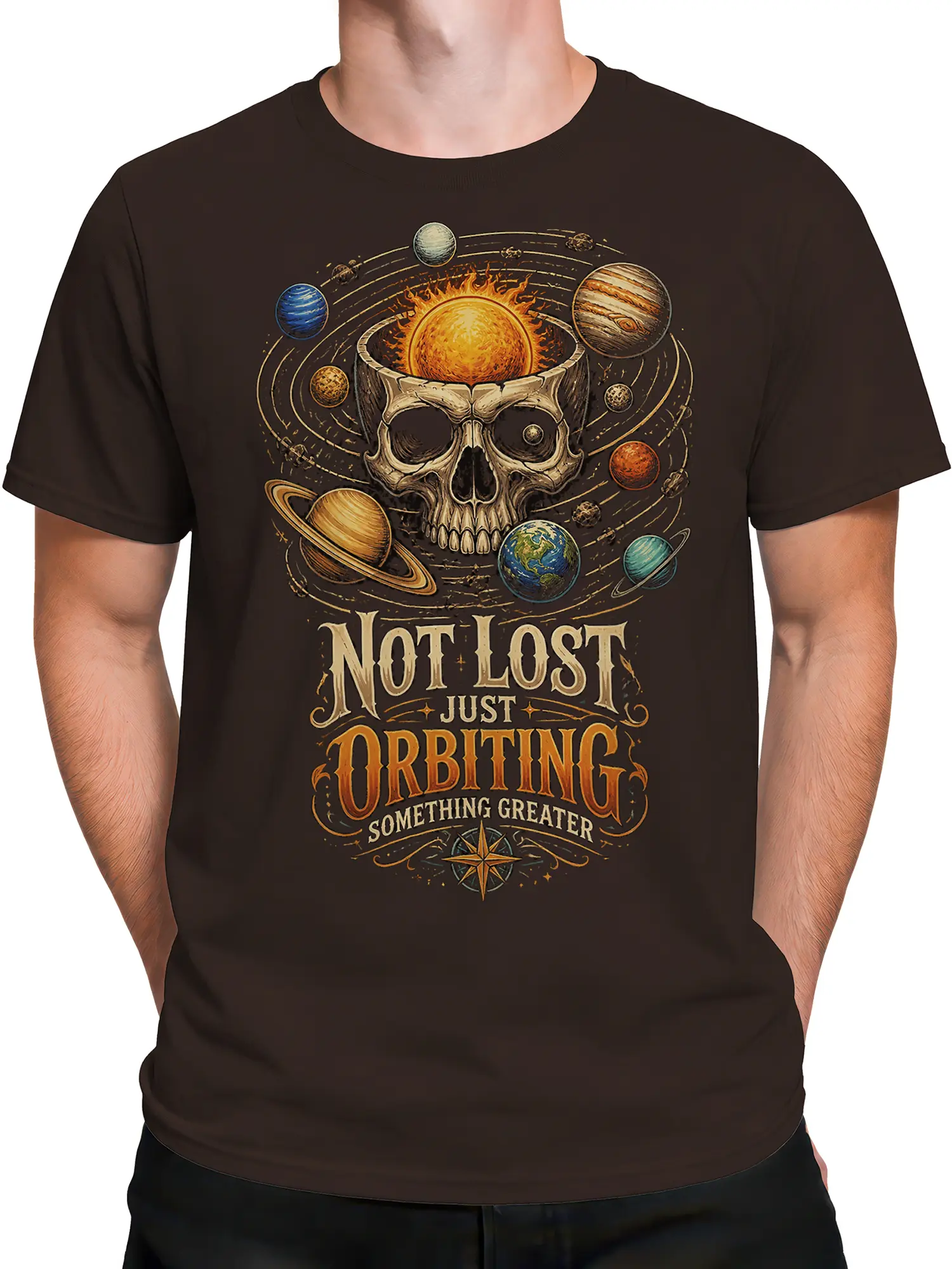 Male torso wearing a dark brown cosmic T-shirt with a skull, planets, and orbiting message