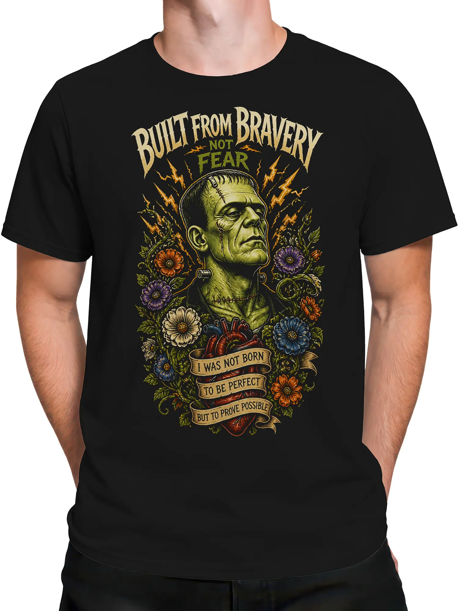 Male torso wearing a black T-shirt with gothic stitched creature and floral artwork