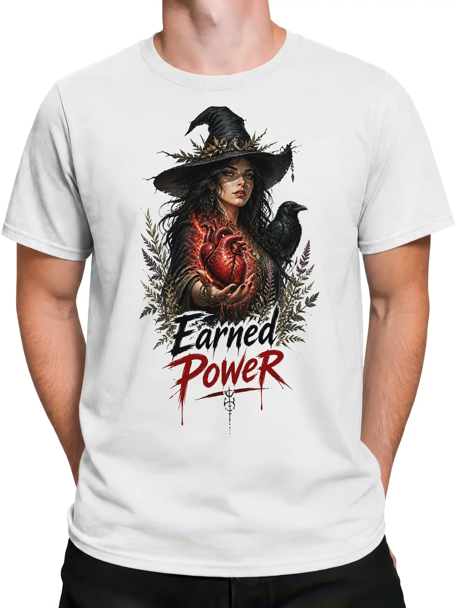 Male torso wearing a white dark fantasy T-shirt with witch, raven, heart, and power artwork