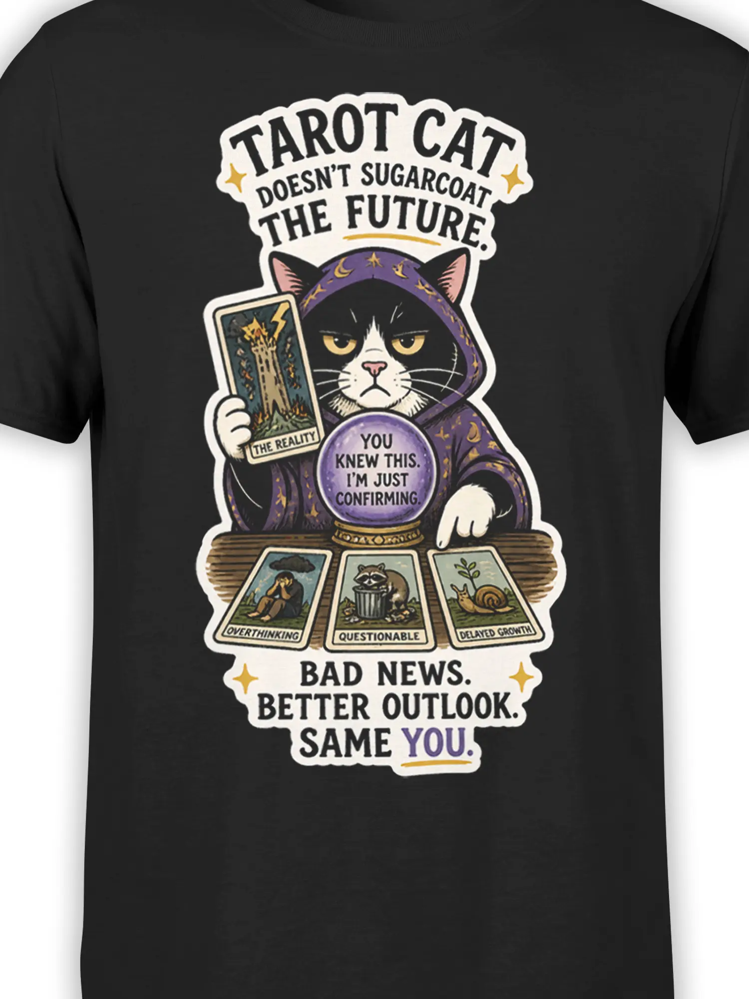 Close-up of hooded black cat tarot artwork with crystal ball and illustrated fortune cards on a black T-shirt