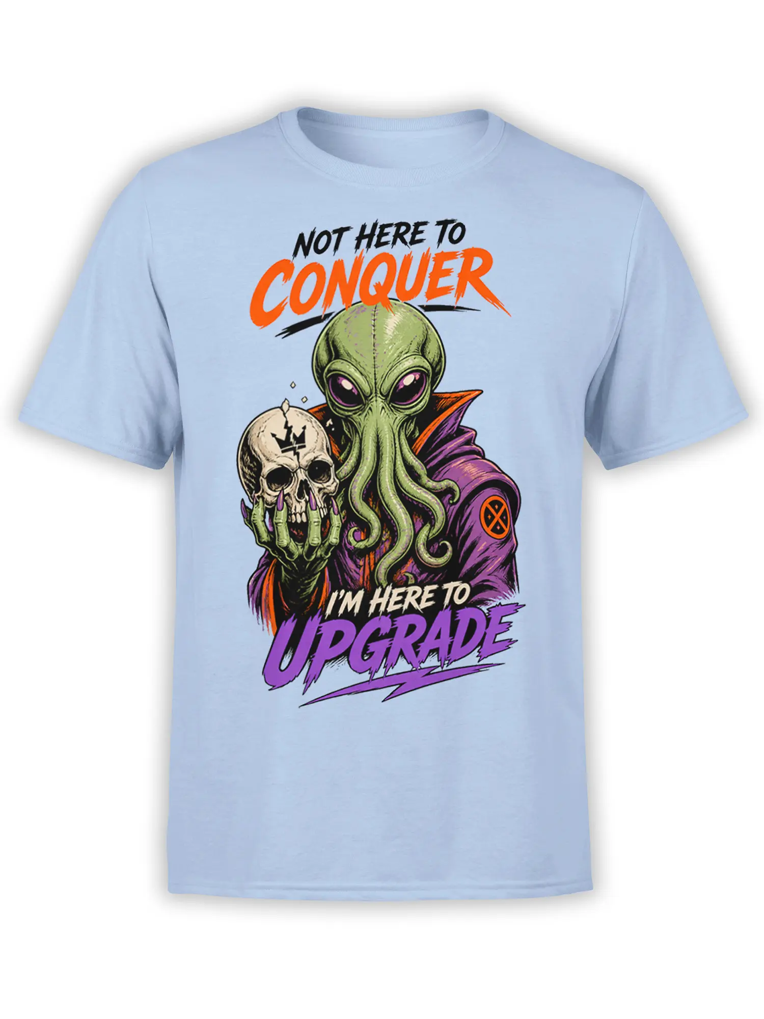 Green alien holding a cracked skull on a light blue shirt with bold “Not Here to Conquer” lettering