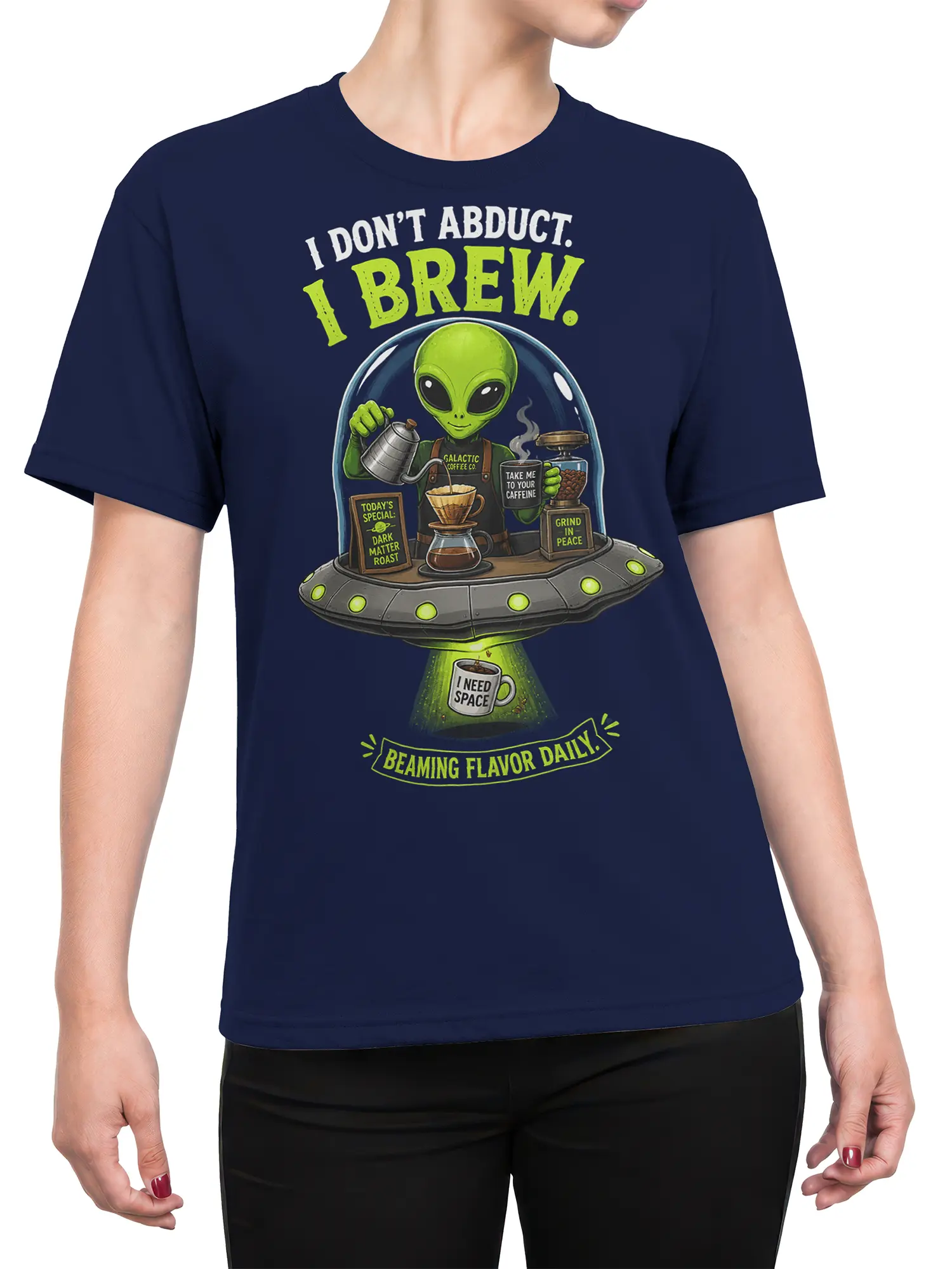 Female torso wearing a navy T-shirt with a green alien coffee barista and flying saucer design