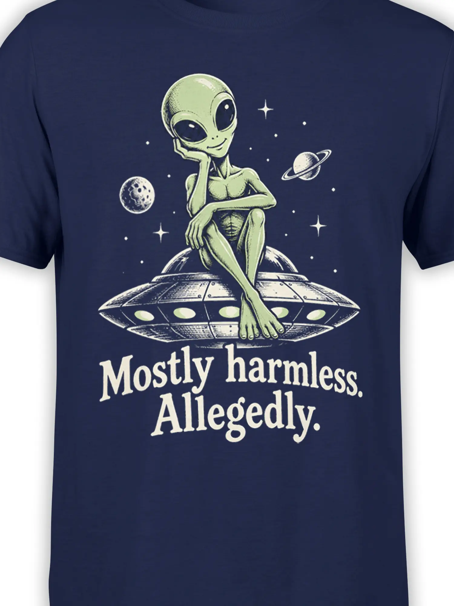 Close-up of green alien and flying saucer artwork with “Mostly harmless. Allegedly.” text on navy fabric