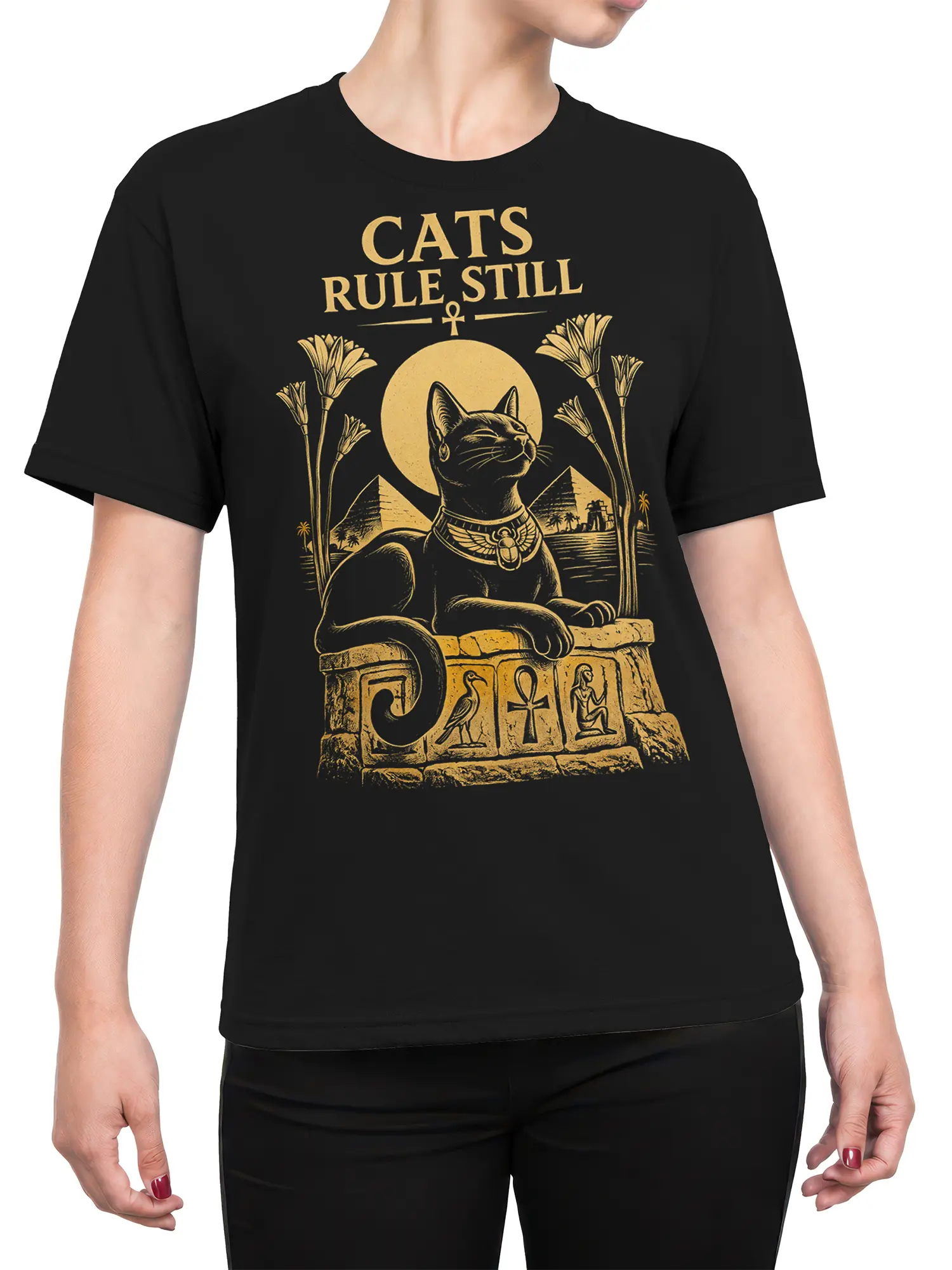 Female torso wearing a black T-shirt with a golden Egyptian cat and “CATS RULE STILL” graphic