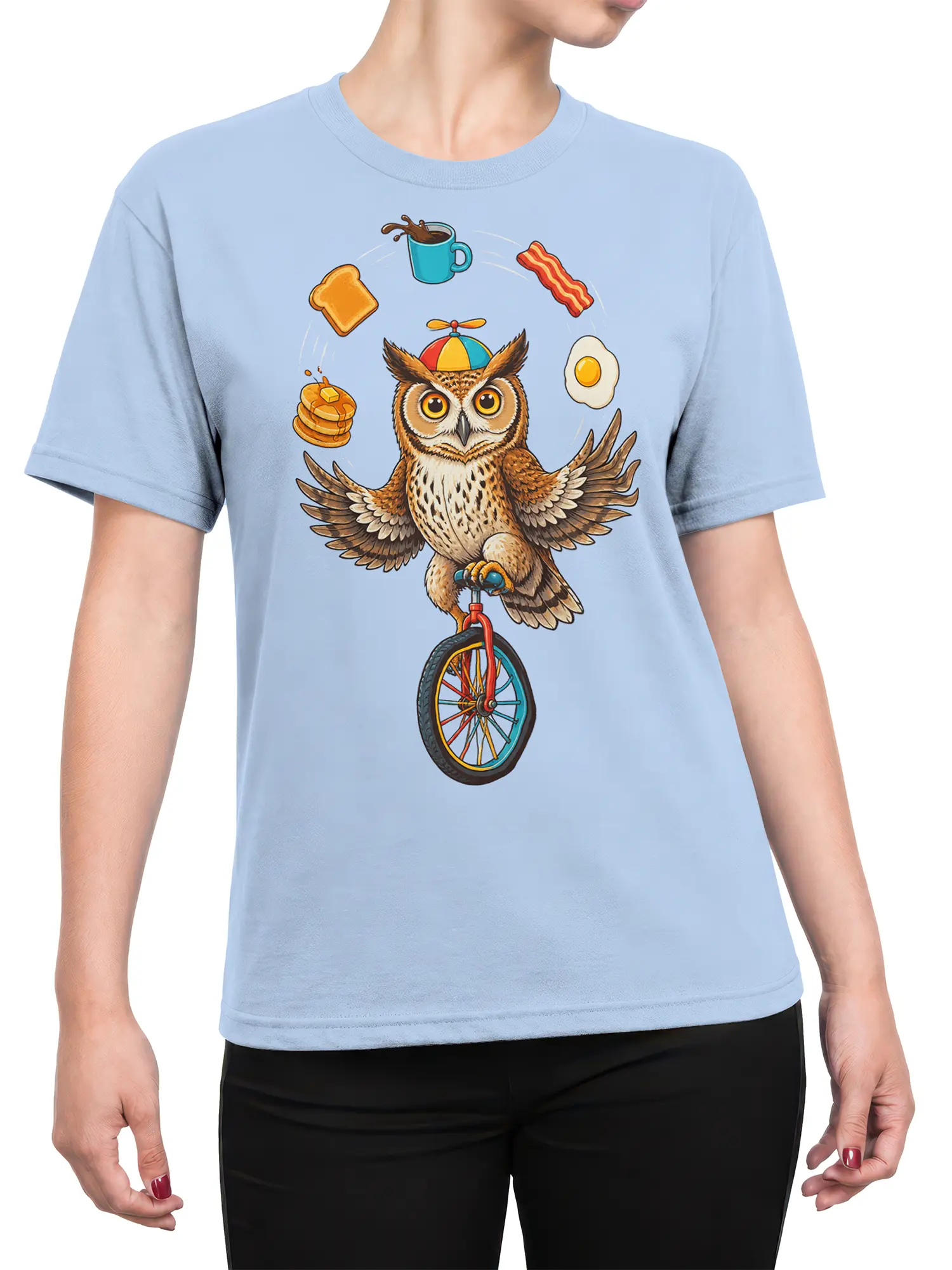 Female torso wearing a light blue shirt with a balancing owl and breakfast food graphic