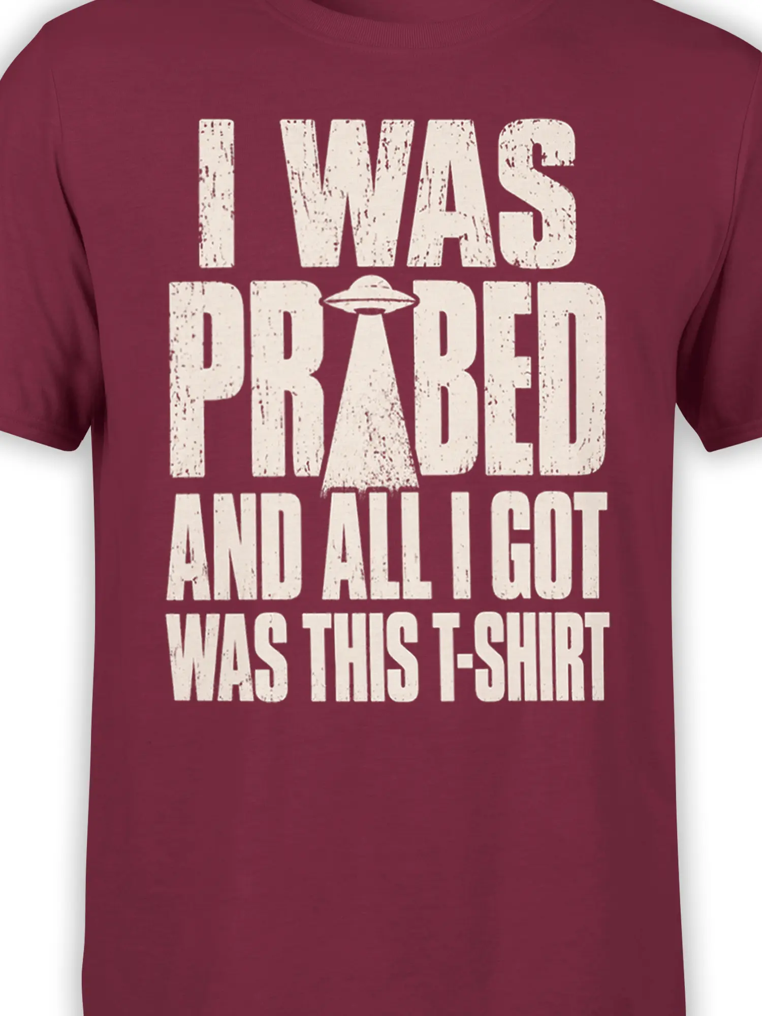 Close-up of distressed cream UFO graphic and slogan on burgundy alien T-shirt