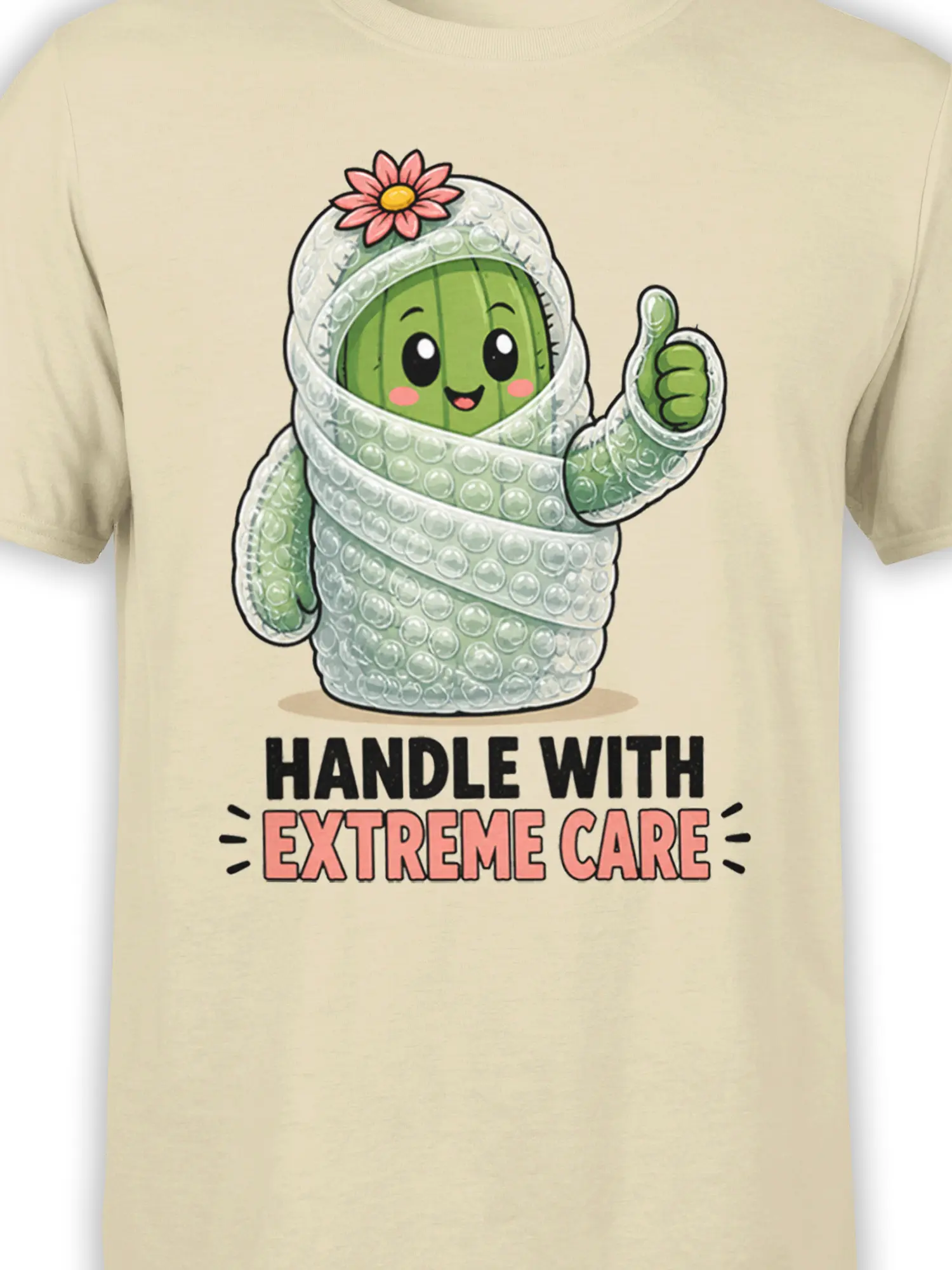 Close-up of the bubble-wrapped green cactus, pink flower, thumbs-up, and bold lettering on a beige graphic tee