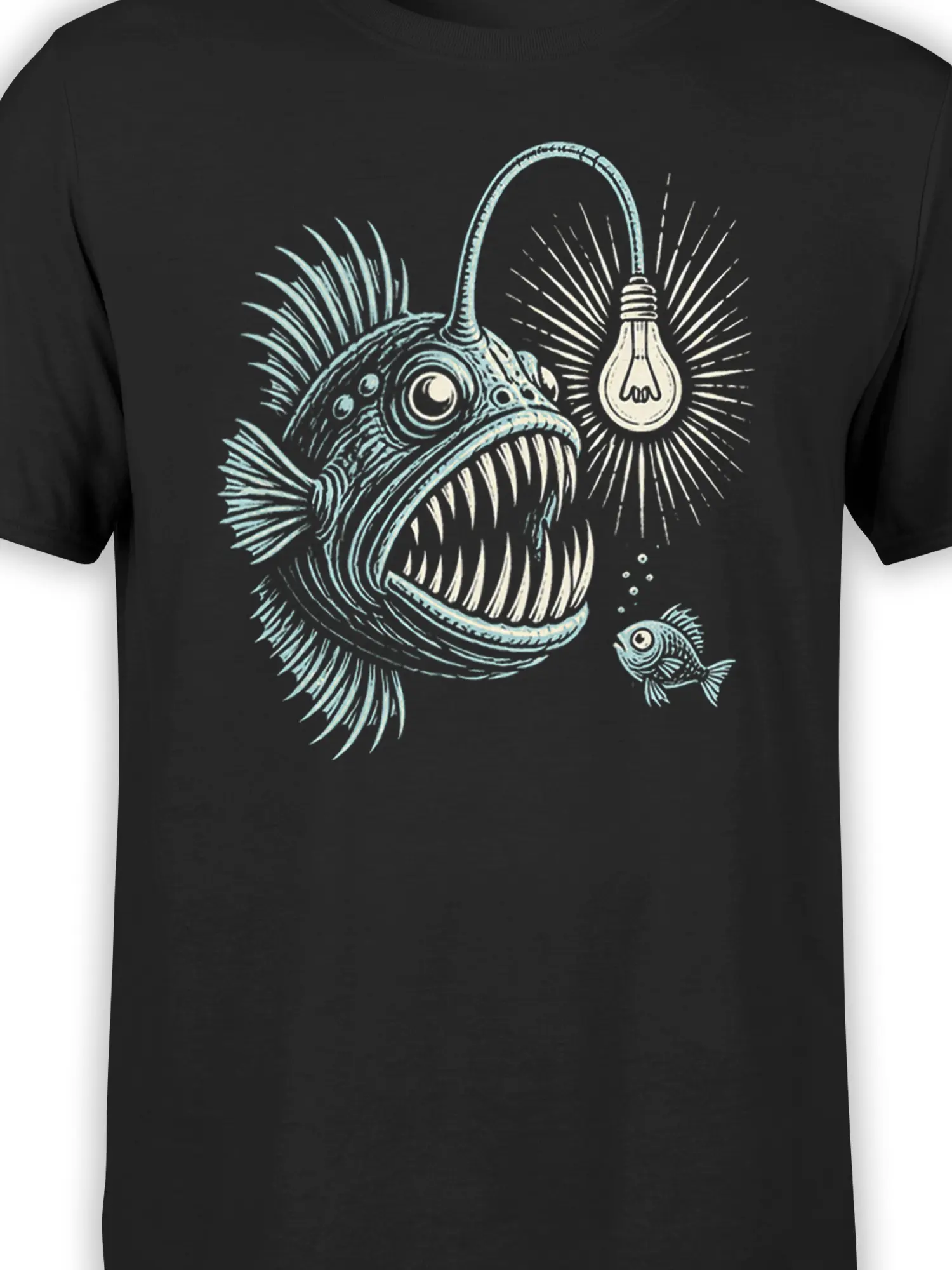 Close-up of the black anglerfish T-shirt graphic showing its glowing lure, large eyes, sharp teeth, and small fish