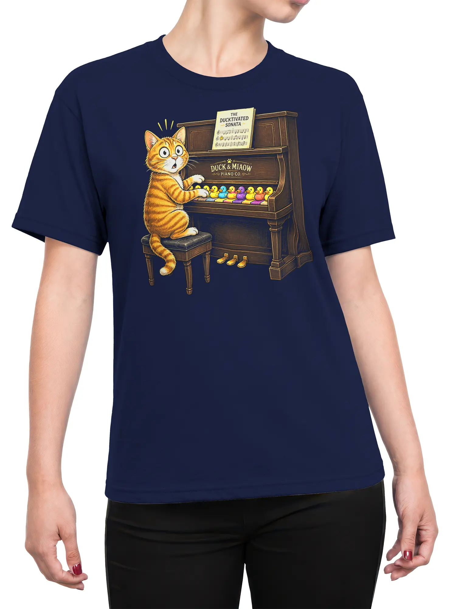 Female torso wearing a navy T-shirt with a tabby cat playing piano for colorful ducks