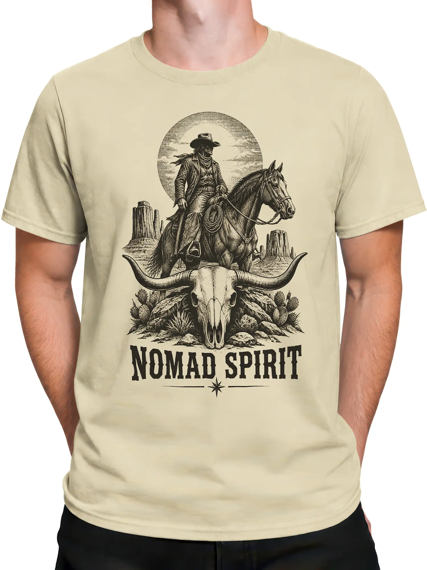 Male torso wearing beige western t-shirt with cowboy rider, desert skull, cacti, and bold lettering