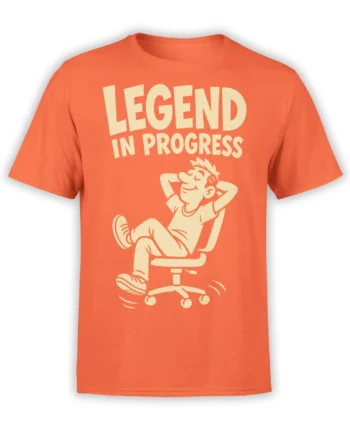 Orange T-shirt featuring a relaxed cartoon office worker and bold cream “LEGEND IN PROGRESS” lettering